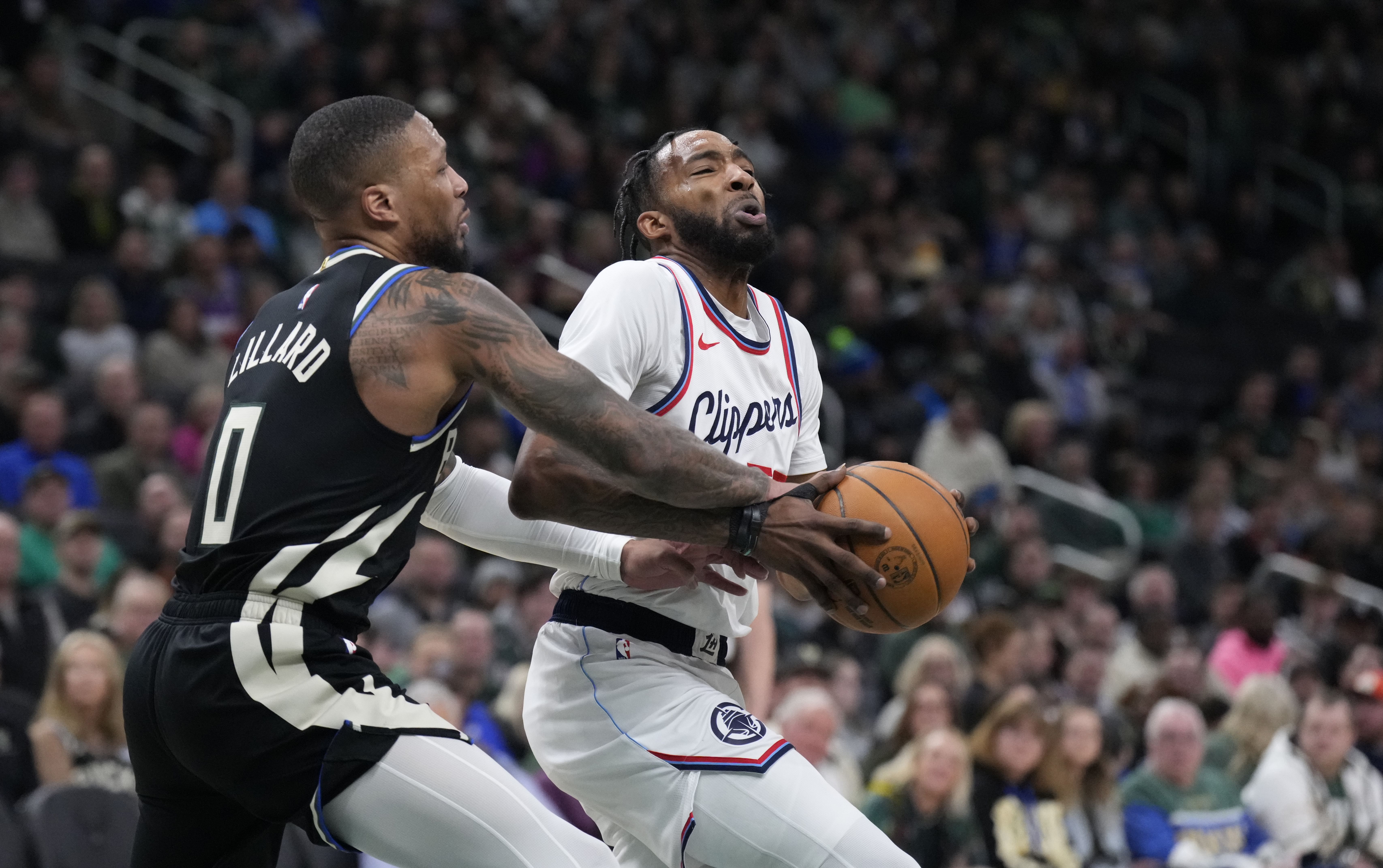 Feb 20, 2025; Milwaukee, Wisconsin, USA; LA Clippers forward Kawhi Leonard (2) drives against Milwaukee Bucks guard Damian Lillard (0) in the first half at Fiserv Forum. Mandatory Credit: Michael McLoone-Imagn Images