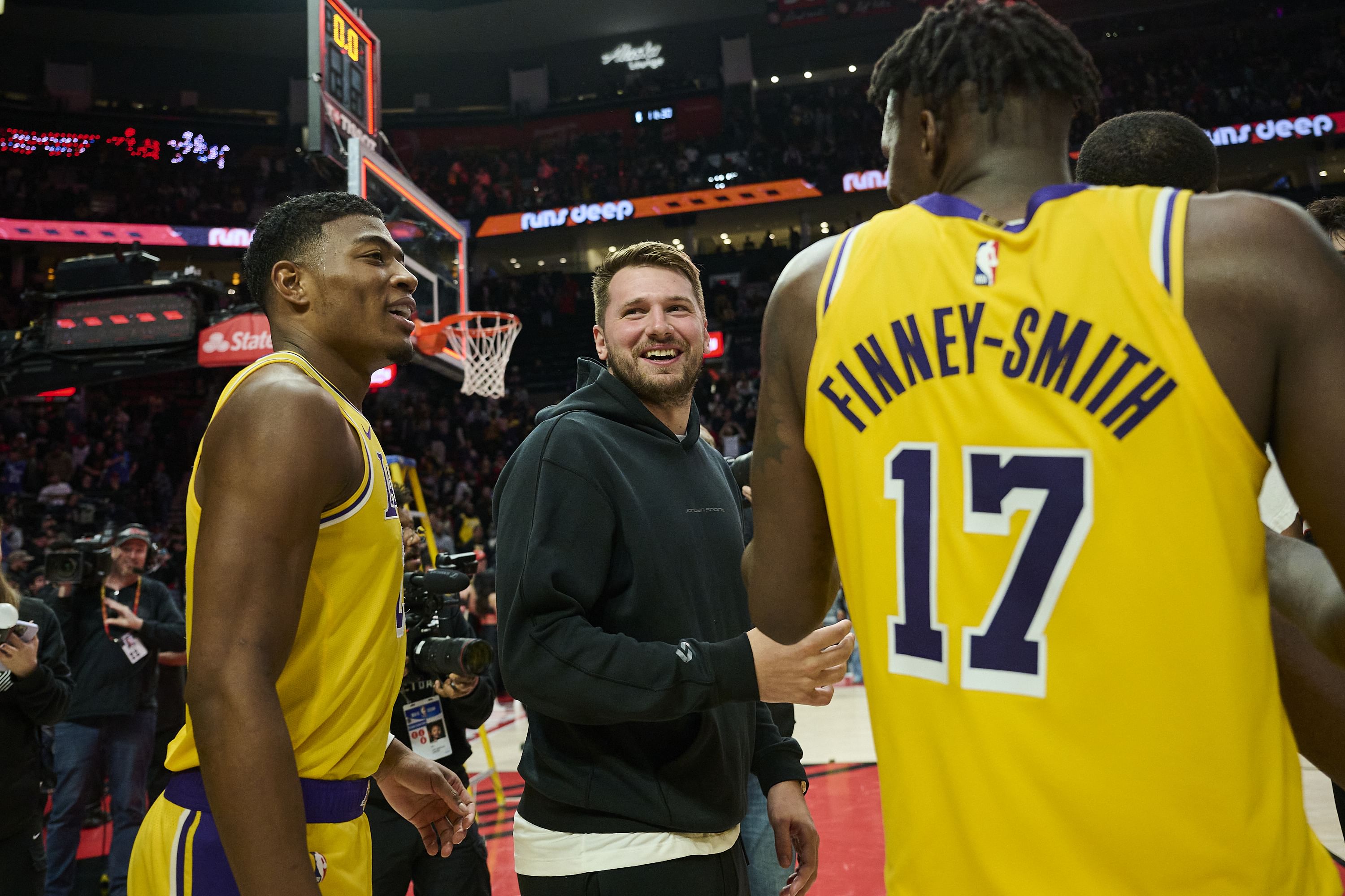 Los Angeles Lakers guard Luka Doncic celebrates with forward Rui Hachimura and forward Dorian Finney-Smith at Moda Center. Photo Credit: Imagn