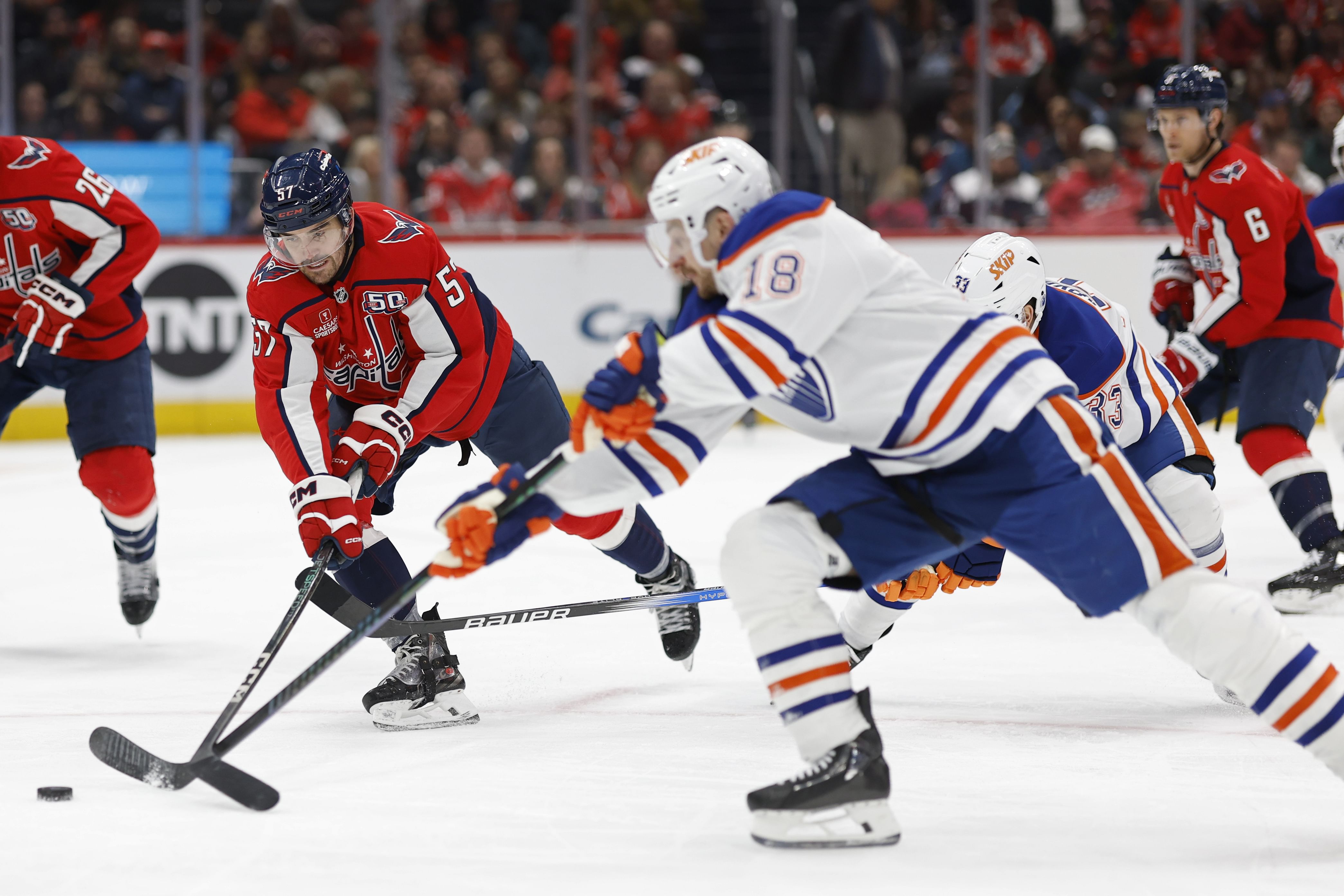 Feb 23, 2025; Washington, District of Columbia, USA; Washington Capitals defenseman Trevor van Riemsdyk (57) knocks the puck from Edmonton Oilers left wing Zach Hyman (18) in the second period at Capital One Arena. Mandatory Credit: Geoff Burke-Imagn Images - Source: Imagn