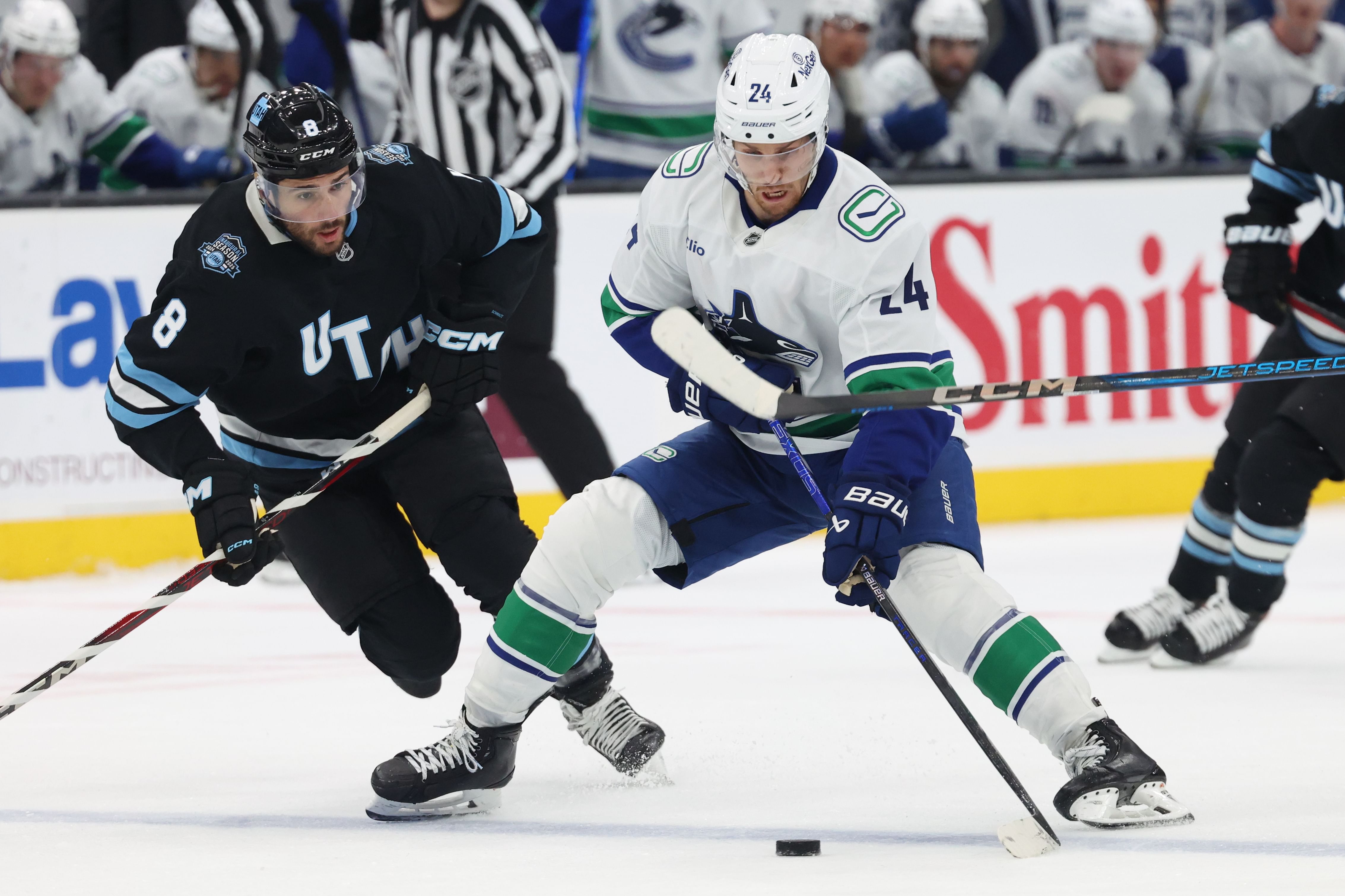 Feb 23, 2025; Salt Lake City, Utah, USA; Vancouver Canucks center Pius Suter (24) skates with the puck against Utah Hockey Club center Nick Schmaltz (8) during the third period at Delta Center. Mandatory Credit: Rob Gray-Imagn Images - Source: Imagn