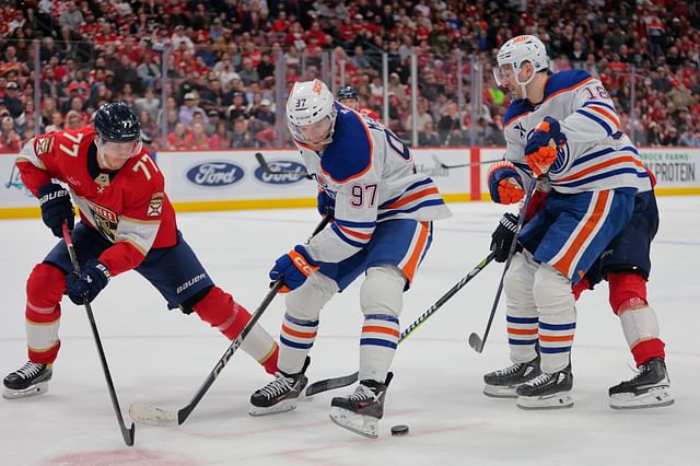 Feb 27, 2025; Sunrise, Florida, USA; Edmonton Oilers center Connor McDavid (97) moves the puck as Florida Panthers defenseman Niko Mikkola (77) defends during the third period at Amerant Bank Arena. Mandatory Credit: Sam Navarro-Imagn Images - Source: Imagn