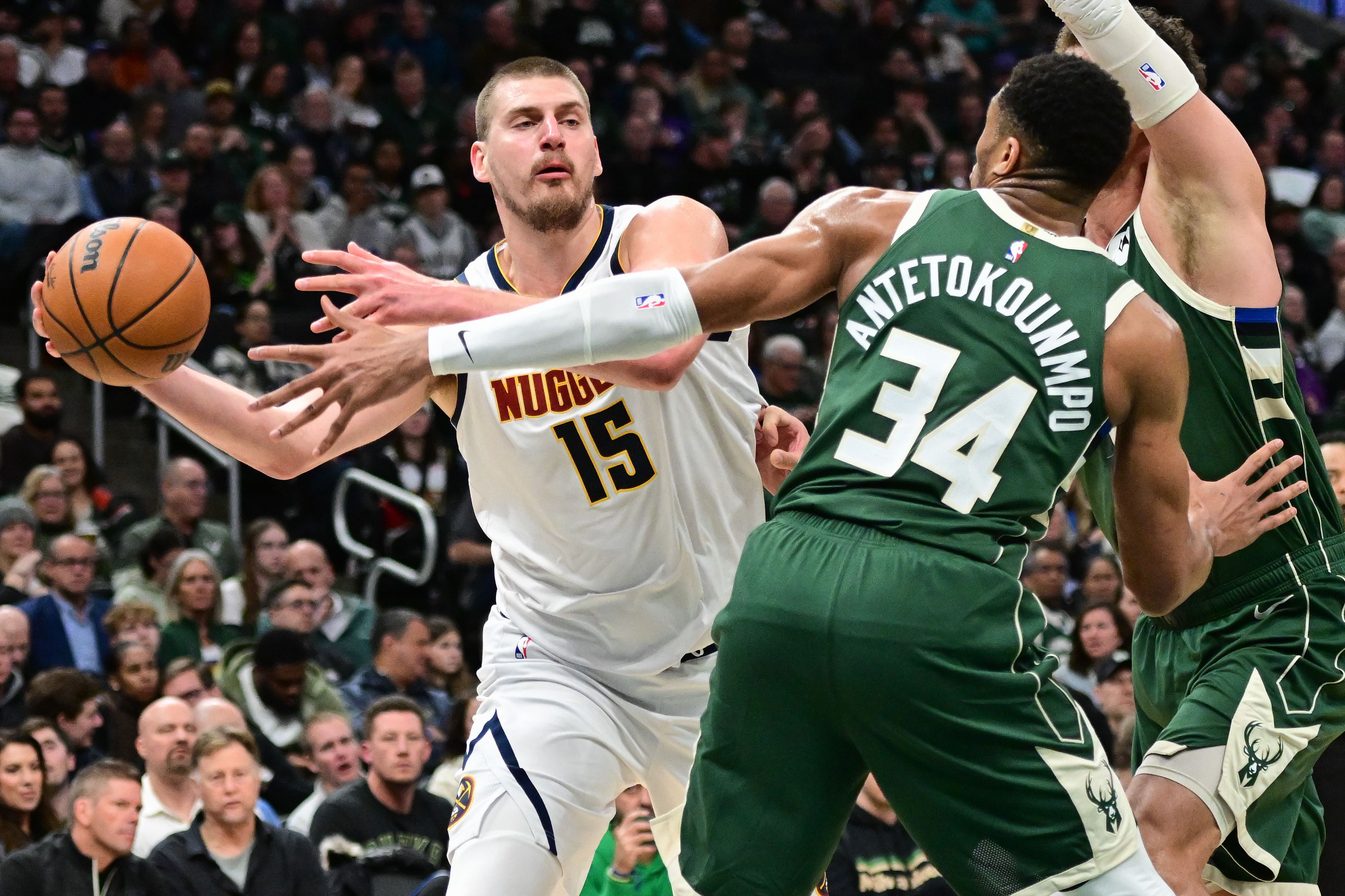 Feb 27, 2025; Milwaukee, Wisconsin, USA; Denver Nuggets center Nikola Jokic (15) looks to pass the ball away from Milwaukee Bucks forward Giannis Antetokounmpo (34) in the third quarter at Fiserv Forum. Mandatory Credit: Benny Sieu-Imagn Images - Source: Imagn