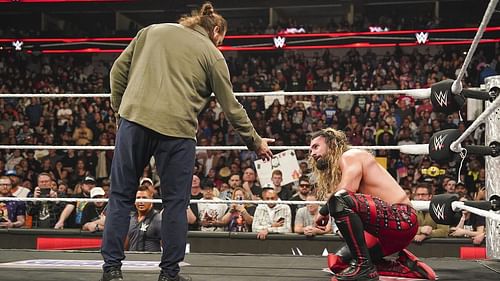 Sami Zayn attempts to help Seth Rollins after accidentally hitting a Helluva Kick on the latter. [Image via WWE.com]