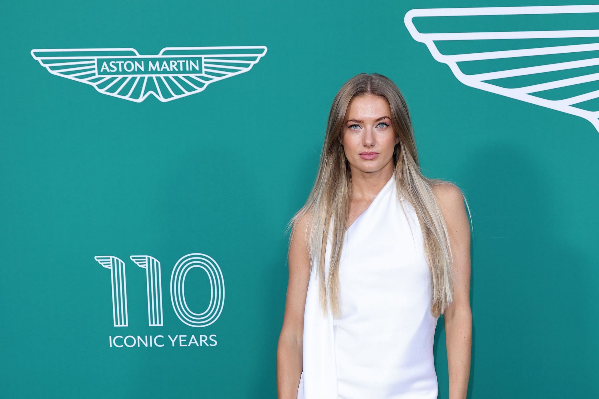 Schmidt donning a white dress during the launch of a new Ashton Martin DB 12 model in 2023 in France (Image via: Getty Images)