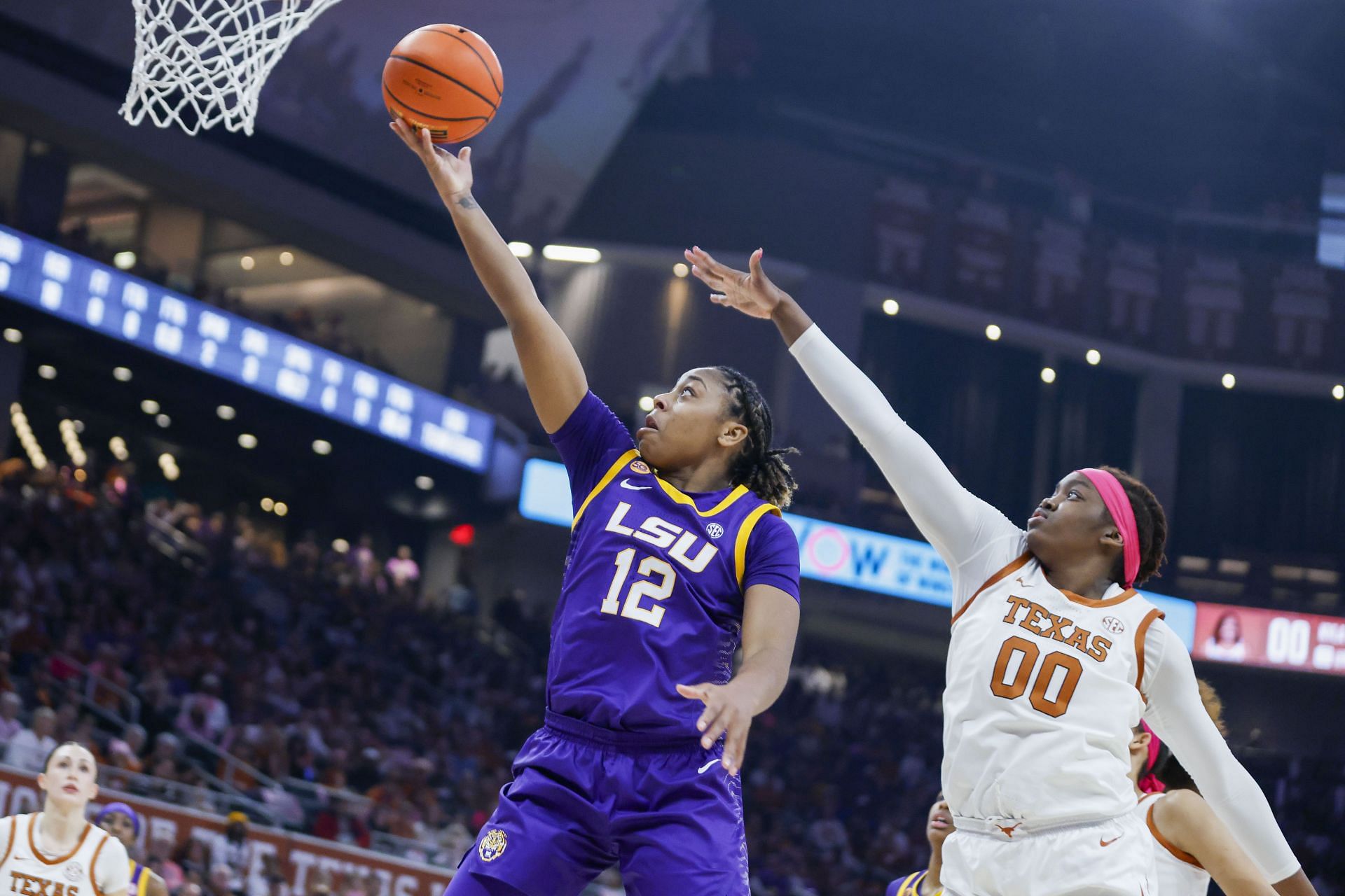 LSU Tigers guard Mikaylah Williams (#12) makes a layup past Texas Longhorns forward Kyla Oldacre (#00) during their game on February 16, 2025, at the Moody Center. Photo: Getty