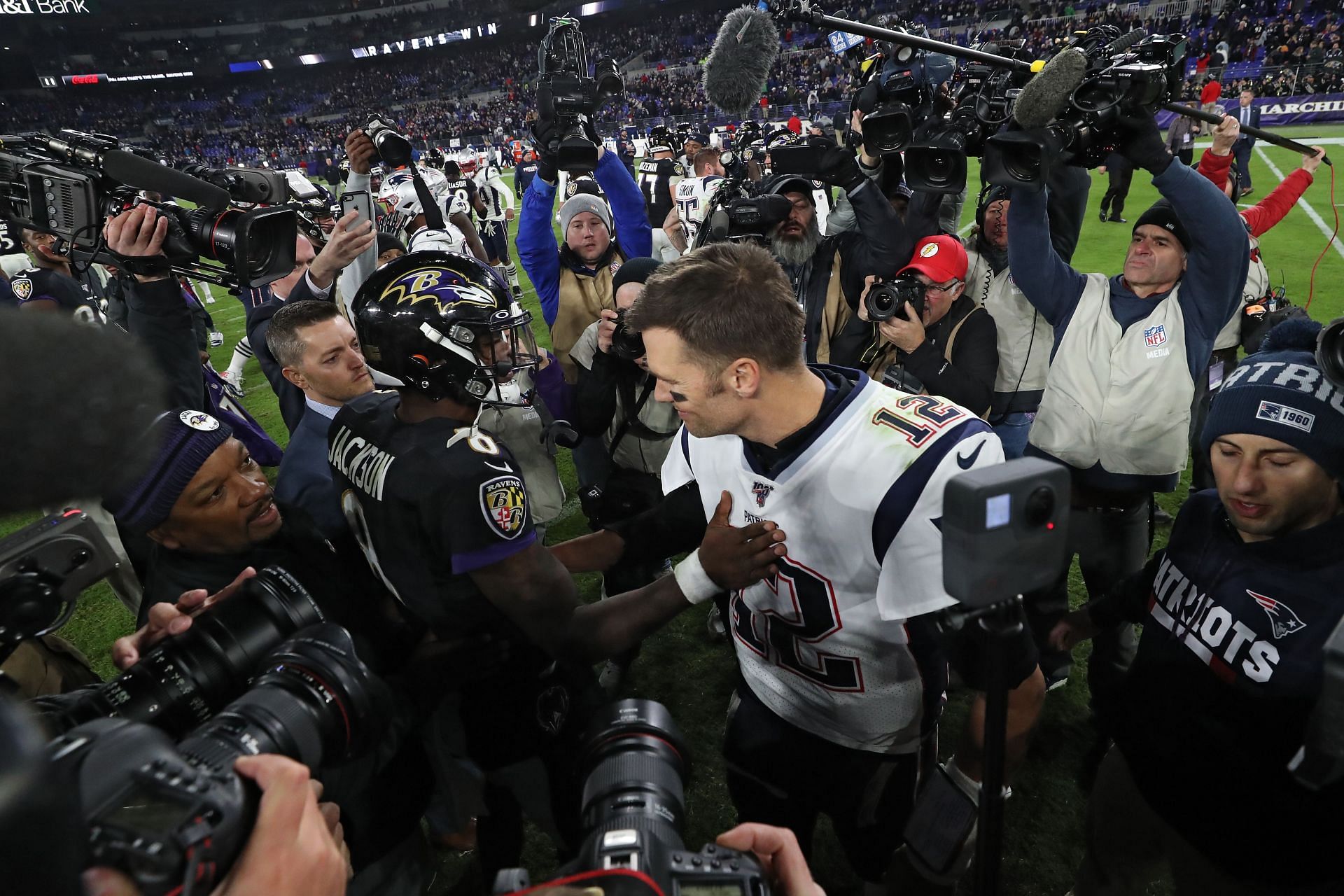  Quarterback Lamar Jackson #8 of the Baltimore Ravens and quarterback Tom Brady #12 of the New England Patriots talk after the Ravens defeated the Patriots at M&amp;T Bank Stadium on November 3, 2019 in Baltimore, Maryland.  - Source: Getty