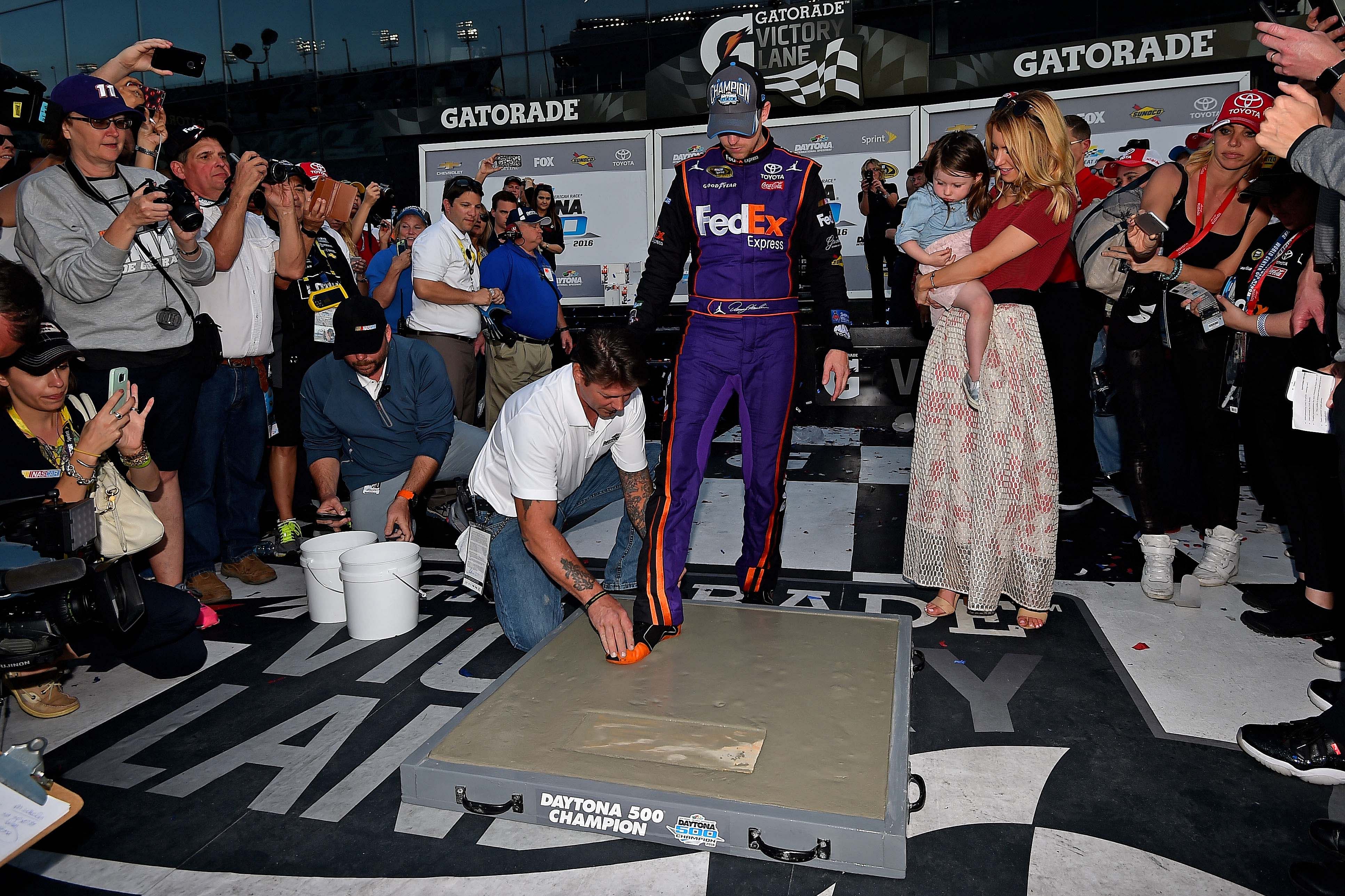 Denny Hamlin (11) steps in concrete after winning the Daytona 500 at Daytona International Speedway. Credit: Jasen Vinlove-Imagn Images