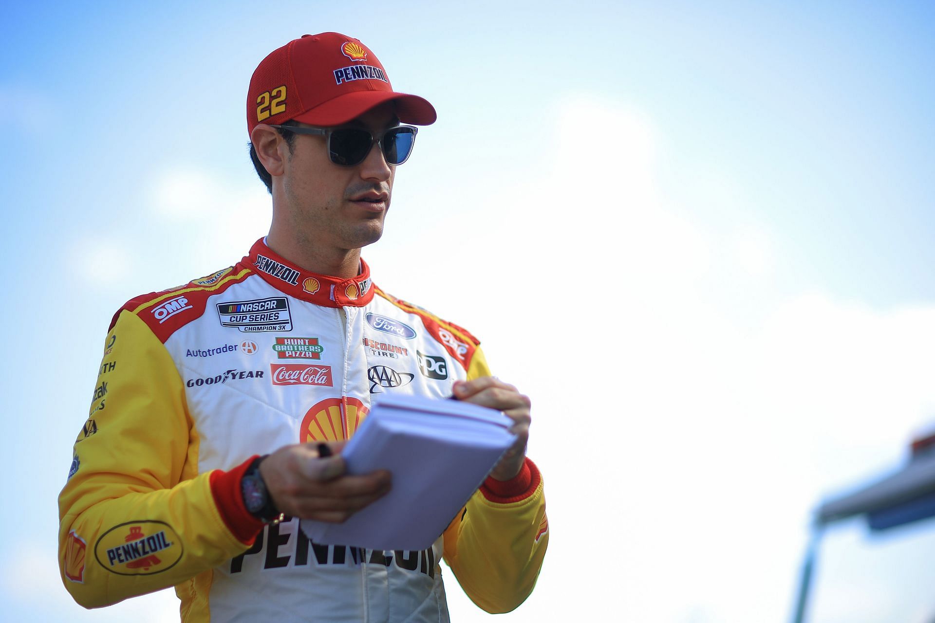 Joey Logano, driver of the #22 Shell Pennzoil Ford signs an autograph for fans during practice (February 12, 2025 in Daytona Beach, Florida. - Source: Getty)