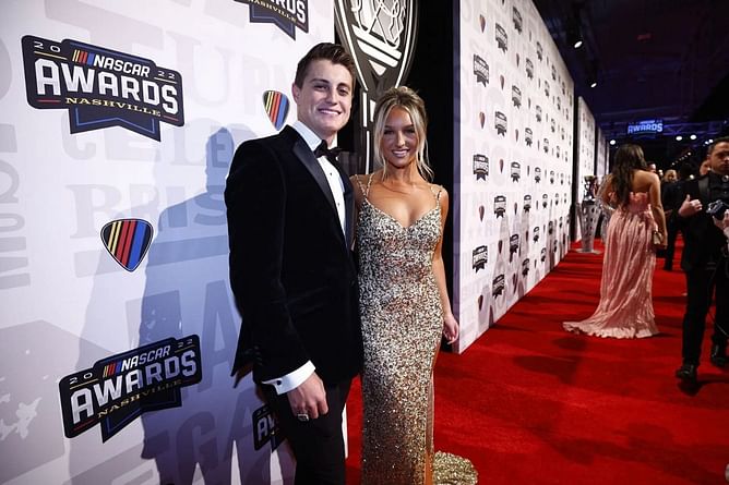 Zane Smith's wife McCall pairs a beige tank top with white pants for Daytona Ignite with Marissa Gilliland