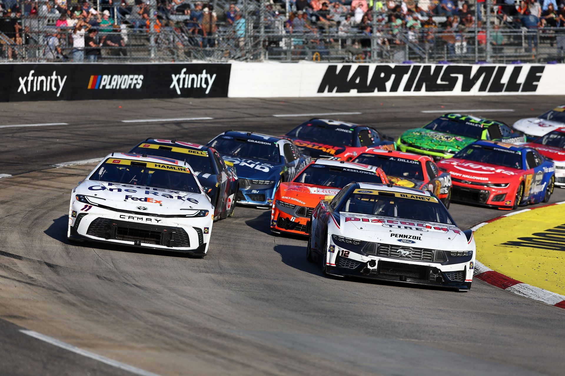 MARTINSVILLE, VIRGINIA - NOVEMBER 03: Denny Hamlin, driver of the #11 FedEx One Rate Toyota, and Ryan Blaney, driver of the #12 Discount Tire Ford, race during the NASCAR Cup Series Xfinity 500 at Martinsville Speedway on November 03, 2024 in Martinsville, Virginia. (Photo by David Jensen/Getty Images) - Source: Getty