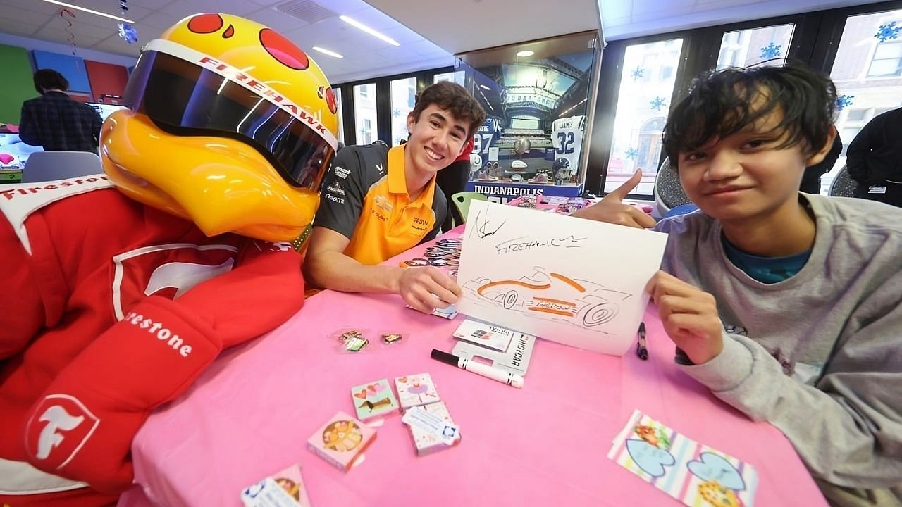 IndyCar driver Nolan Siegel with mascot Firestone Firehawk at Riley