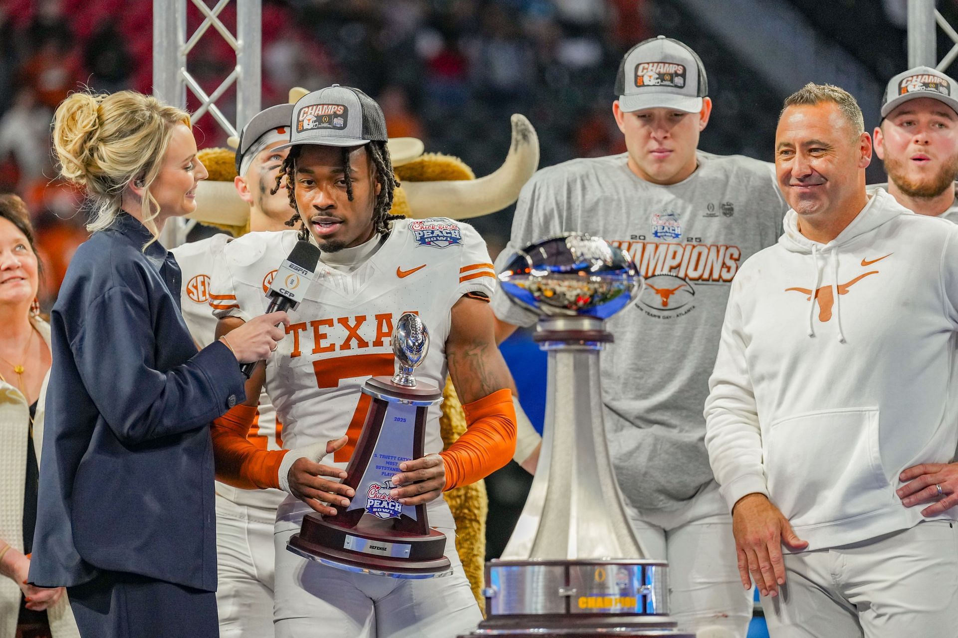 Isaiah Bond #7 of the Texas Longhorns is interviewed with the championship trophy alongside head coach Steve Sarkisian of the Texas Longhorns at the Chick-fil-A Peach Bowl - Source: Getty