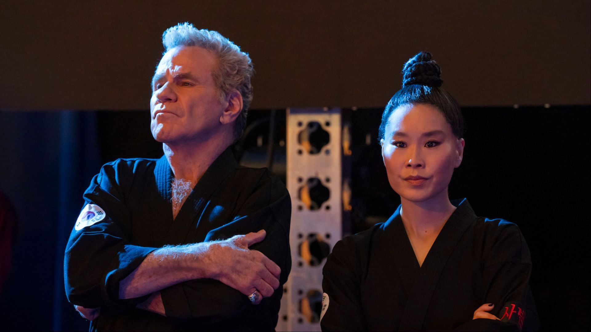 Kreese and Master Kim Da-Eun exude authority as they plan their strategy for the Sekai Taikai. (Image via Netflix Tudum)