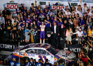 Denny Hamlin (11) celebrates with the Harley J. Earl Trophy in victory lane. - Source: Imagn