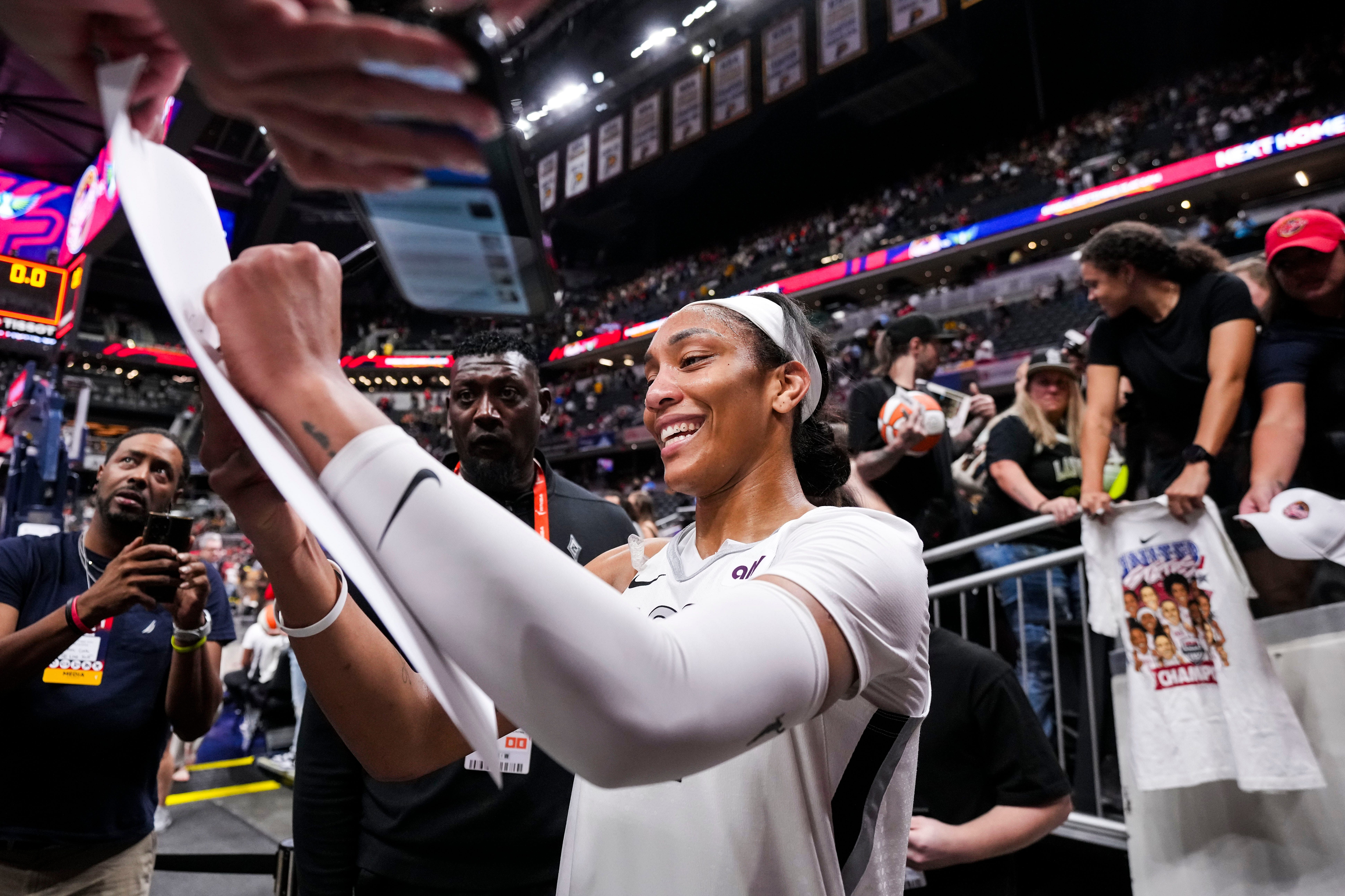 Las Vegas Aces center A&#039;ja Wilson signs a poster during a game between the Indiana Fever and the Las Vegas Aces at Gainbridge Fieldhouse. Photo Credit: Imagn