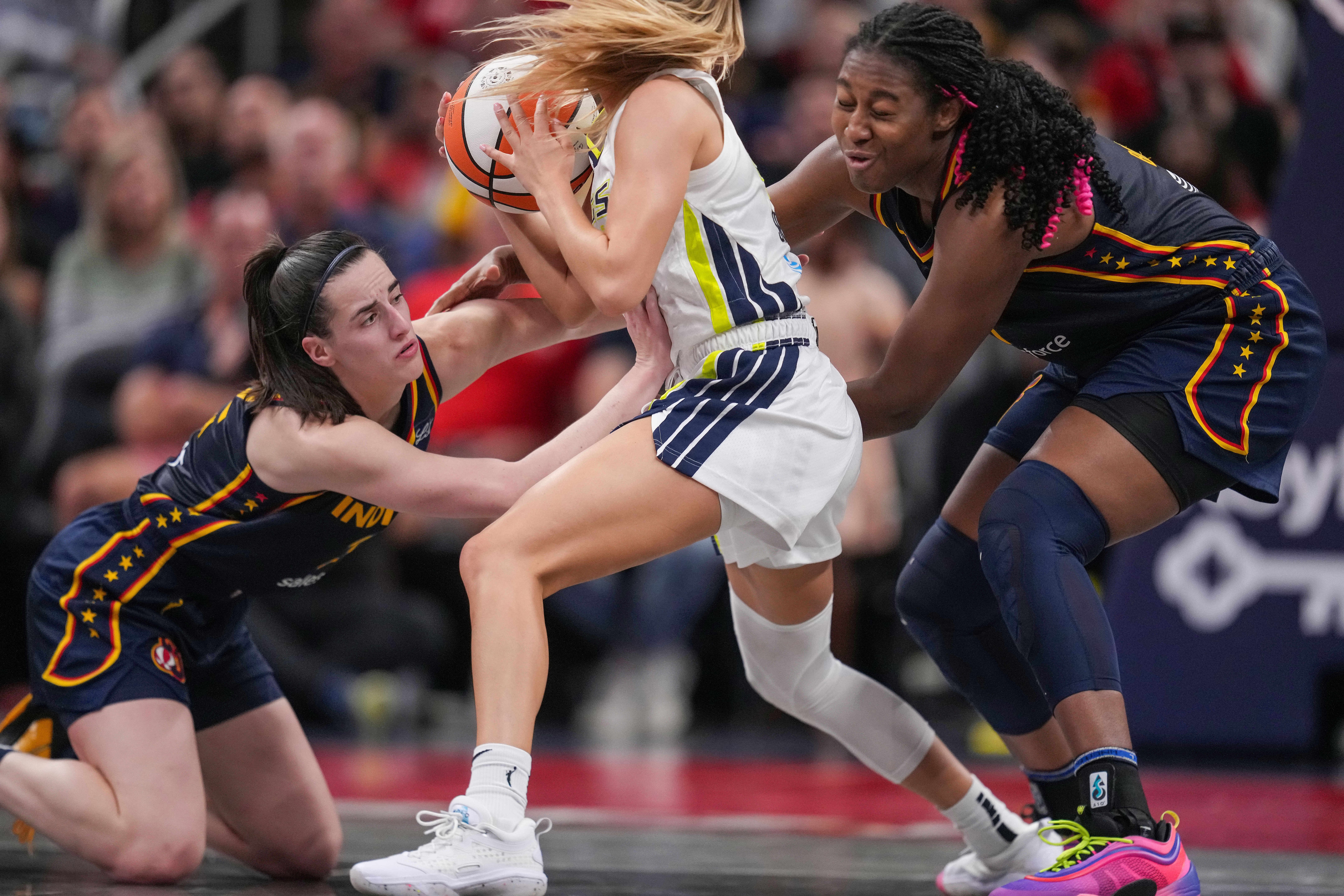 Sep 15, 2024; Indianapolis, Indiana, USA; Indiana Fever guard Caitlin Clark (22) and forward Aliyah Boston (7) lose the ball against Dallas Wings guard Jacy Sheldon (4) at Gainbridge Fieldhouse. Mandatory Credit: Grace Hollars/USA TODAY Network via Imagn Images - Source: Imagn