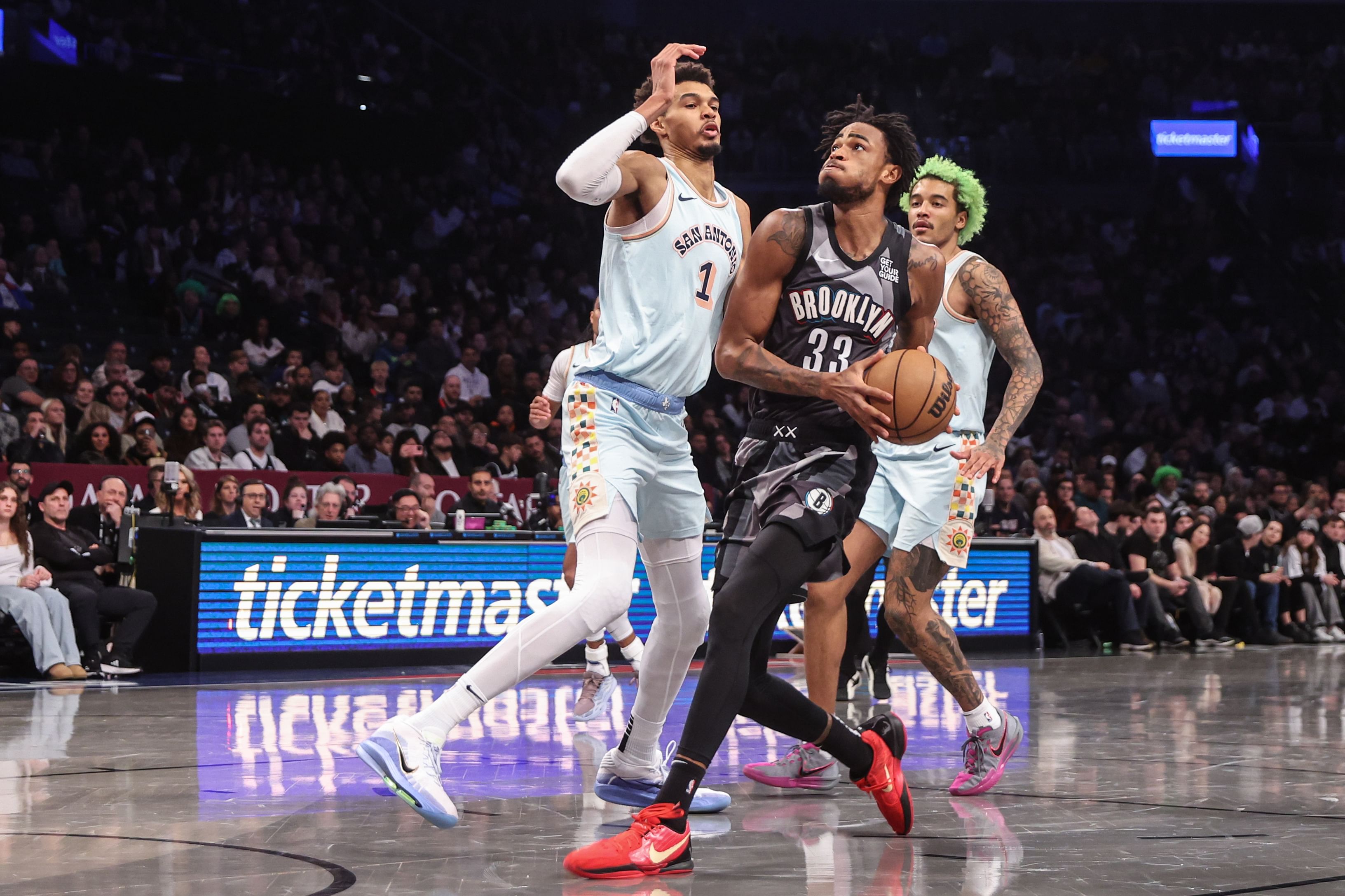 Dec 27, 2024; Brooklyn, New York, USA; Brooklyn Nets center Nic Claxton (33) looks to drive past San Antonio Spurs center Victor Wembanyama (1) in the fourth quarter at Barclays Center. Mandatory Credit: Wendell Cruz-Imagn Images - Source: Imagn