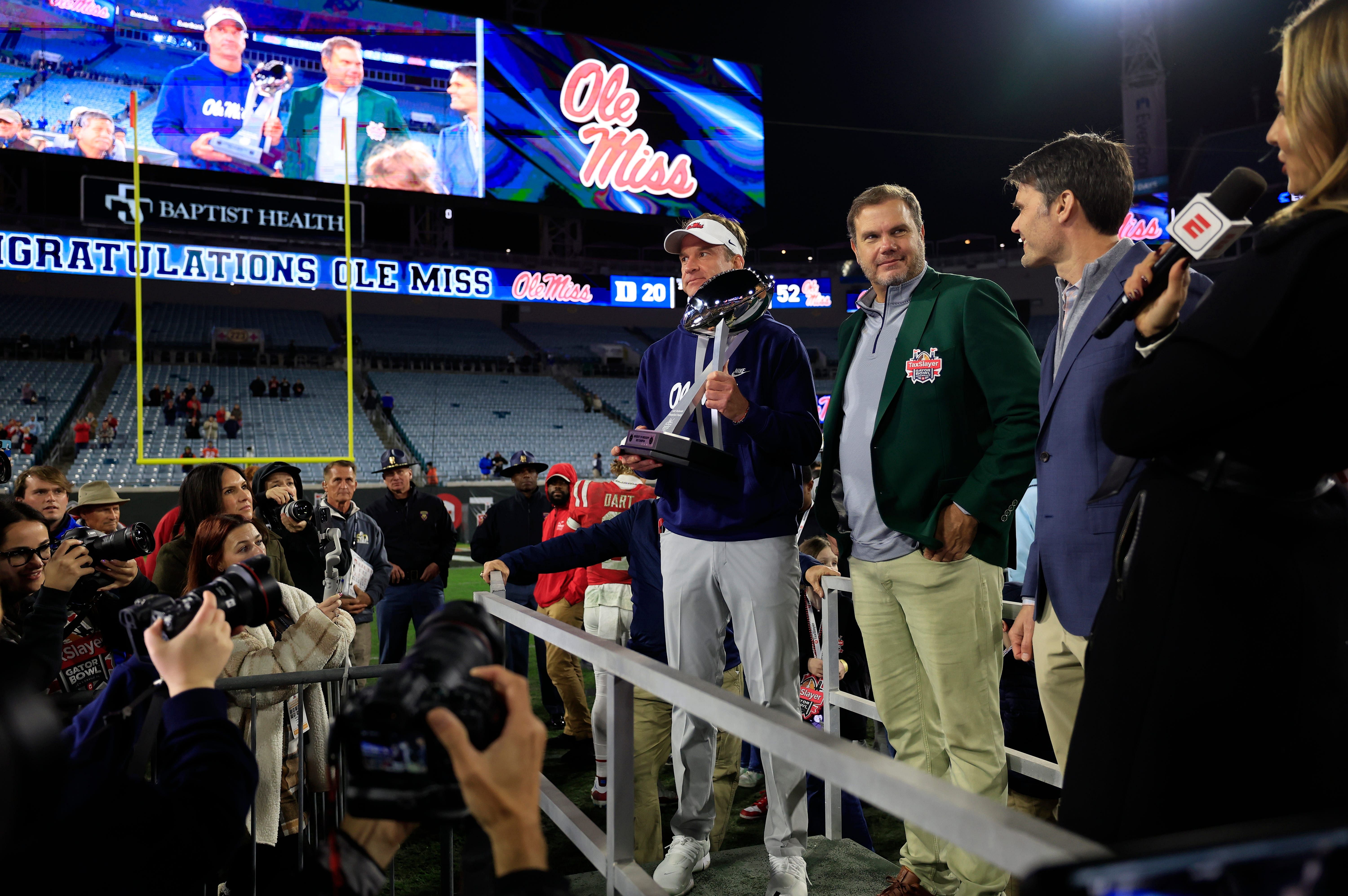 Lane Kiffin holds the Ash Verlander Champions Trophy - Source: Imagn