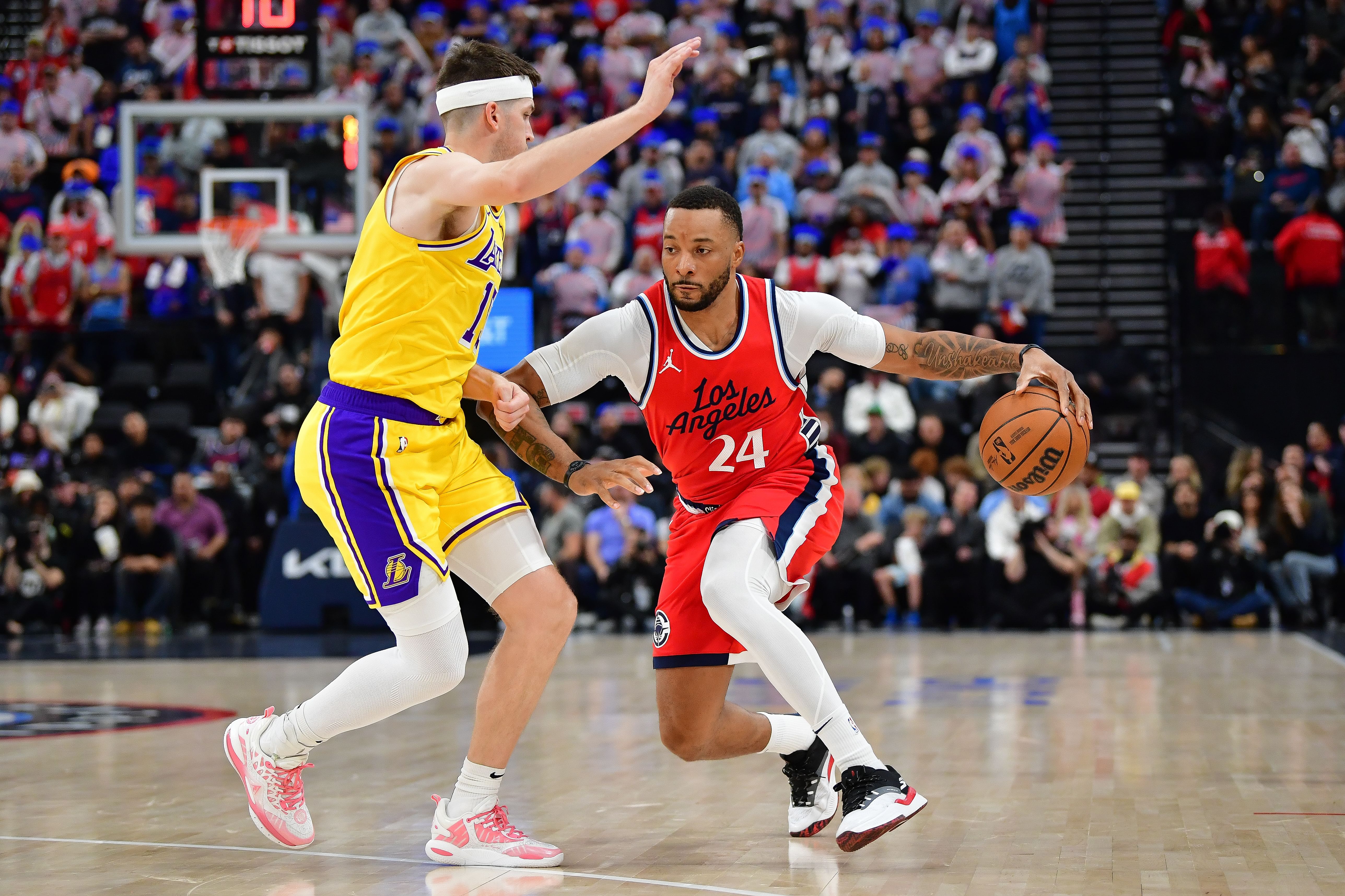 Feb 4, 2025; Inglewood, California, USA; Los Angeles Clippers guard Norman Powell (24) moves the ball against Los Angeles Lakers guard Austin Reaves (15) during the first half at Intuit Dome. Mandatory Credit: Gary A. Vasquez-Imagn Images - Source: Imagn