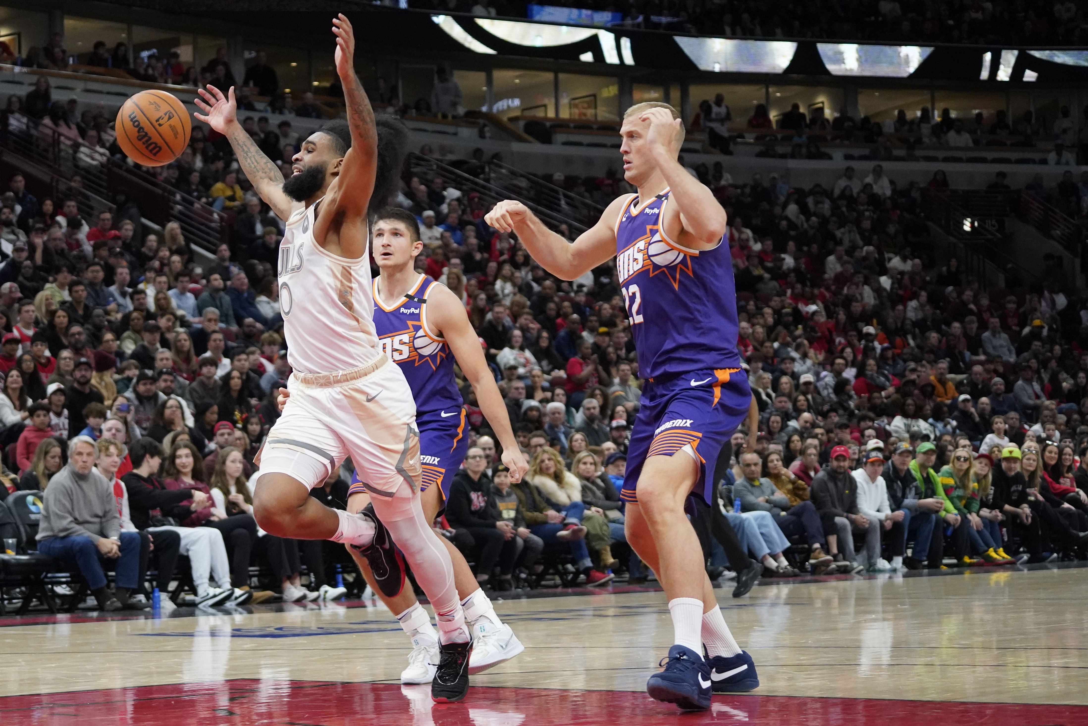 Feb 22, 2025; Chicago, Illinois, USA; Phoenix Suns center Mason Plumlee (22) defends Chicago Bulls guard Coby White (0) during the second half at United Center. Mandatory Credit: David Banks-Imagn Images - Source: Imagn