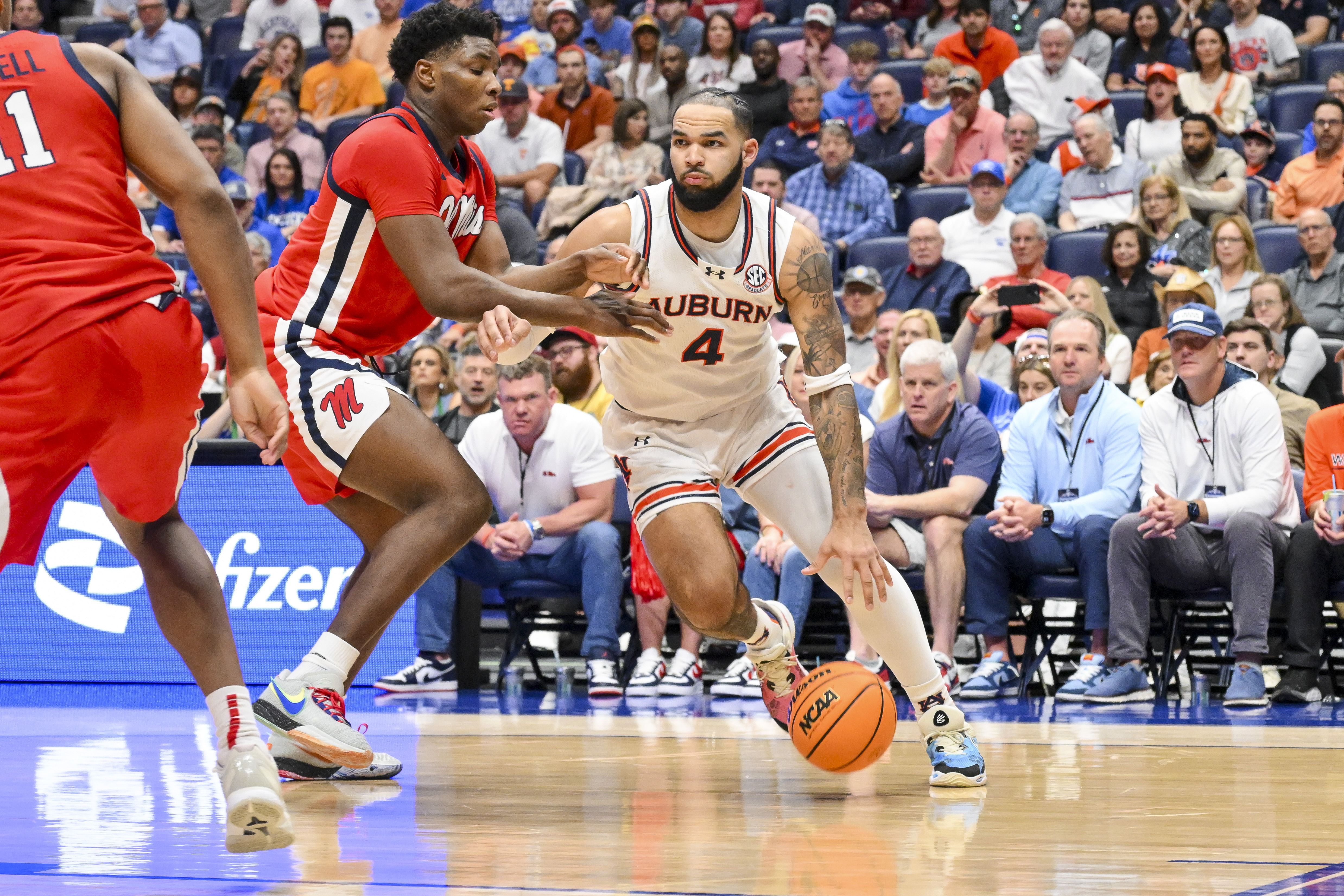 Auburn Tigers forward Johni Broome (4) dribbles past Mississippi Rebels forward Malik Dia (0) during the first half at Bridgestone Arena. Photo: Imagn