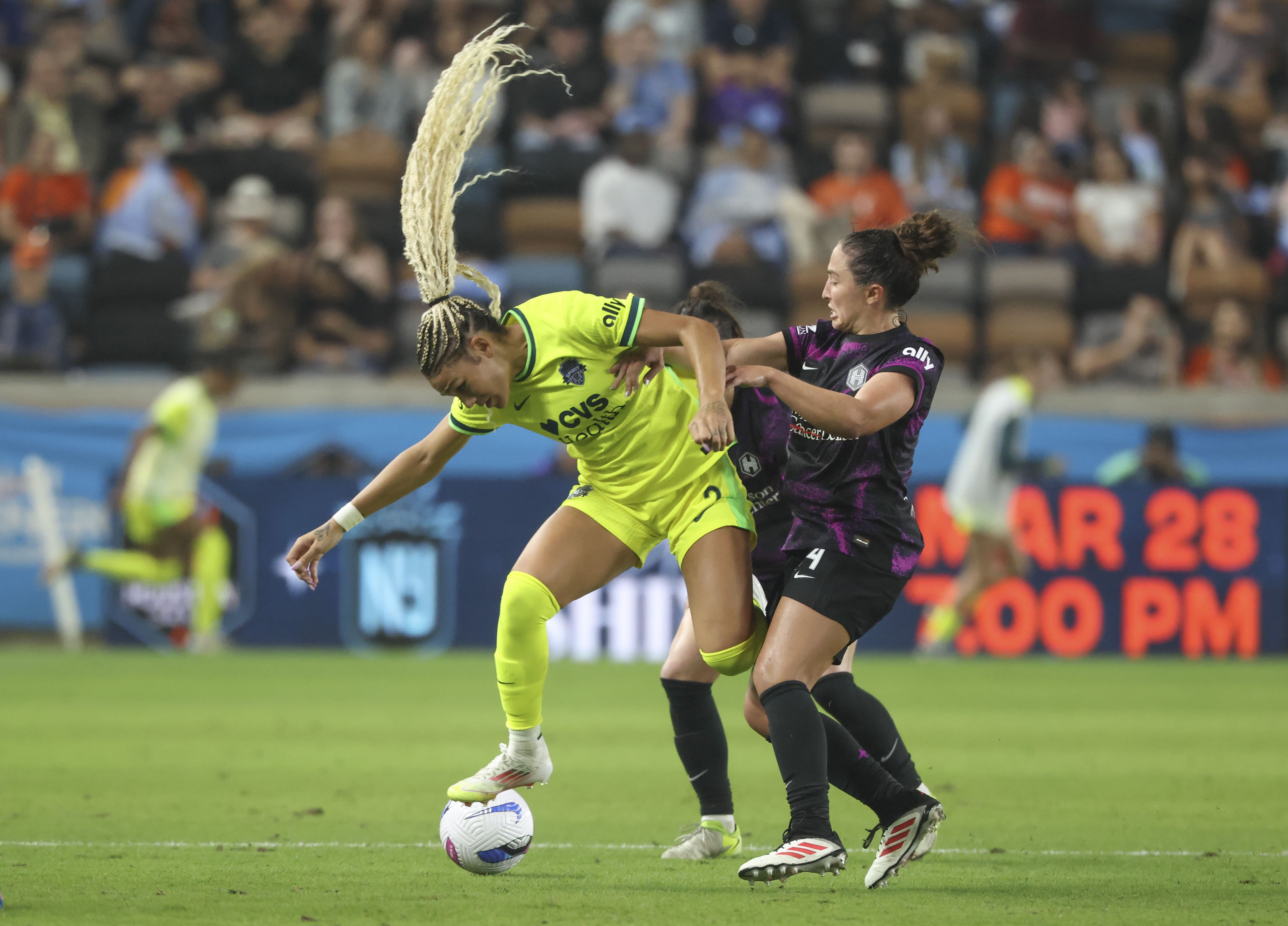 Mar 14, 2025; Houston, Texas, USA; Washington Spirit forward Trinity Rodman (2) attempts to control the ball as Houston Dash defender Paige Nielson (14) defends during the second half at Shell Energy Stadium. Mandatory Credit: Troy Taormina-Imagn Images - Source: Imagn