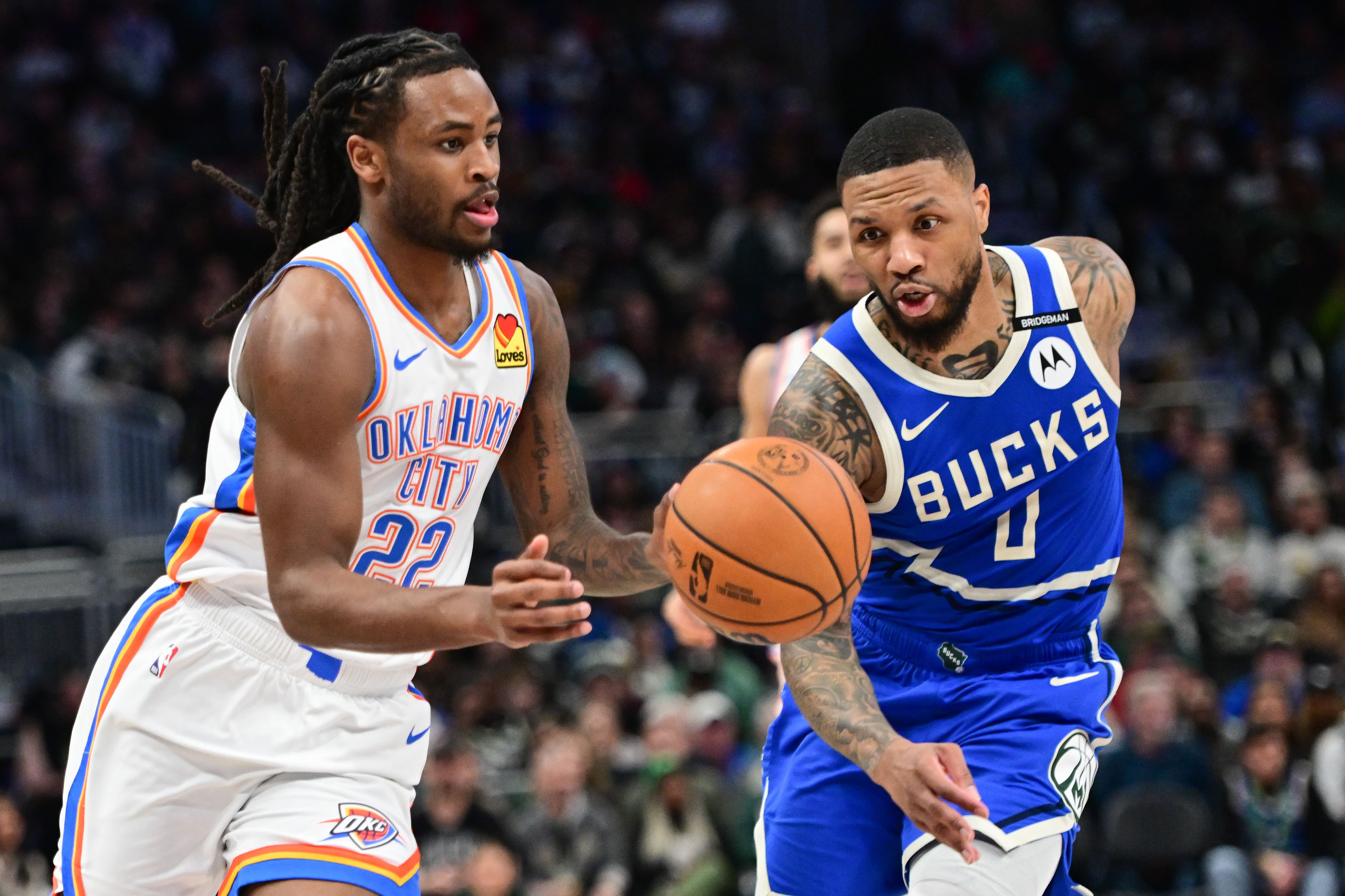 Mar 16, 2025; Milwaukee, Wisconsin, USA; Oklahoma City Thunder guard Cason Wallace (22) drives for the basket against Milwaukee Bucks guard Damian Lillard (0) in the second quarter at Fiserv Forum. Mandatory Credit: Benny Sieu-Imagn Images - Source: Imagn