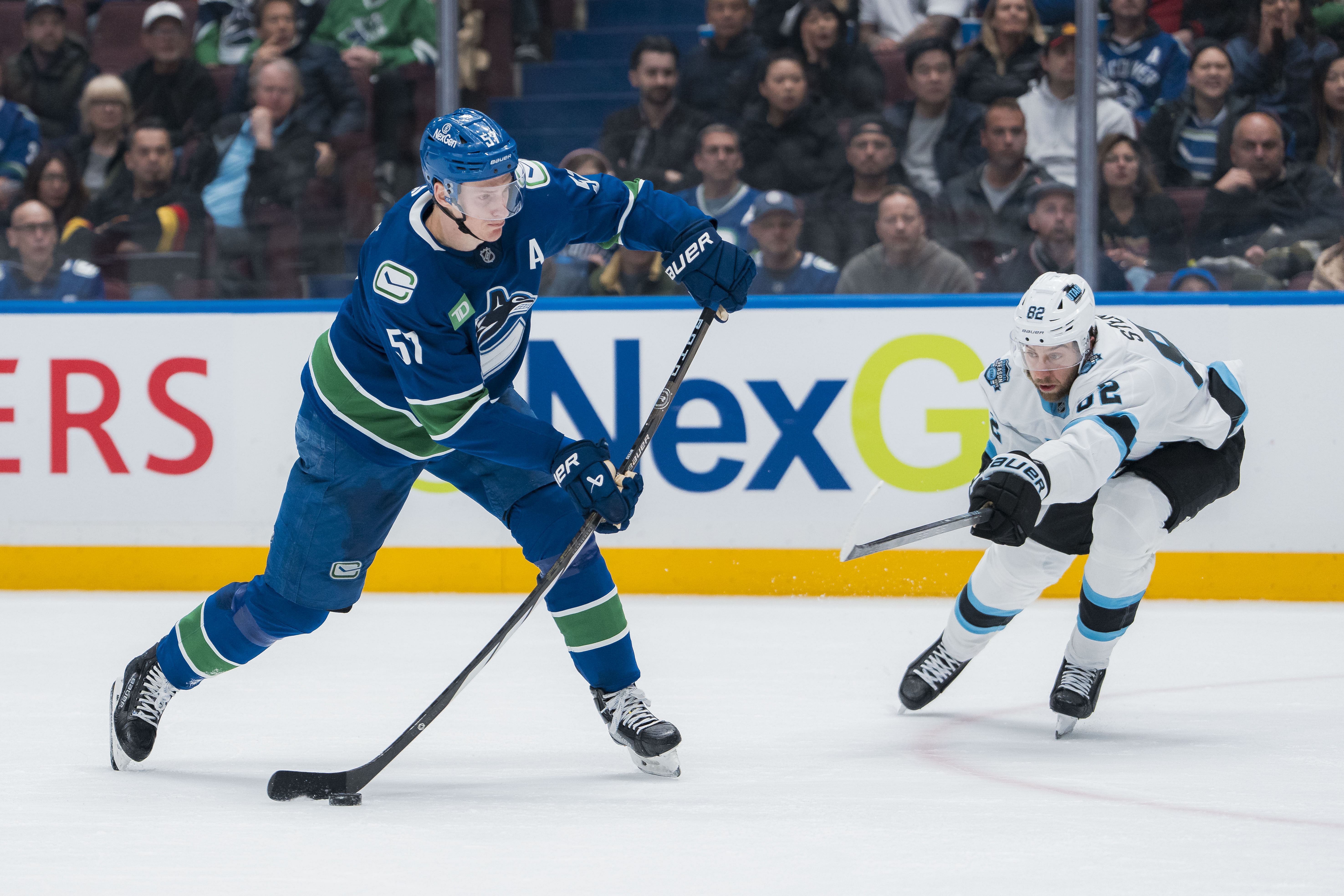 Mar 16, 2025; Vancouver, British Columbia, CAN; Vancouver Canucks defenseman Tyler Myers (57) shoots past Utah Hockey Club forward Kevin Stenlund (82)in the third period at Rogers Arena. Mandatory Credit: Bob Frid-Imagn Images - Source: Imagn