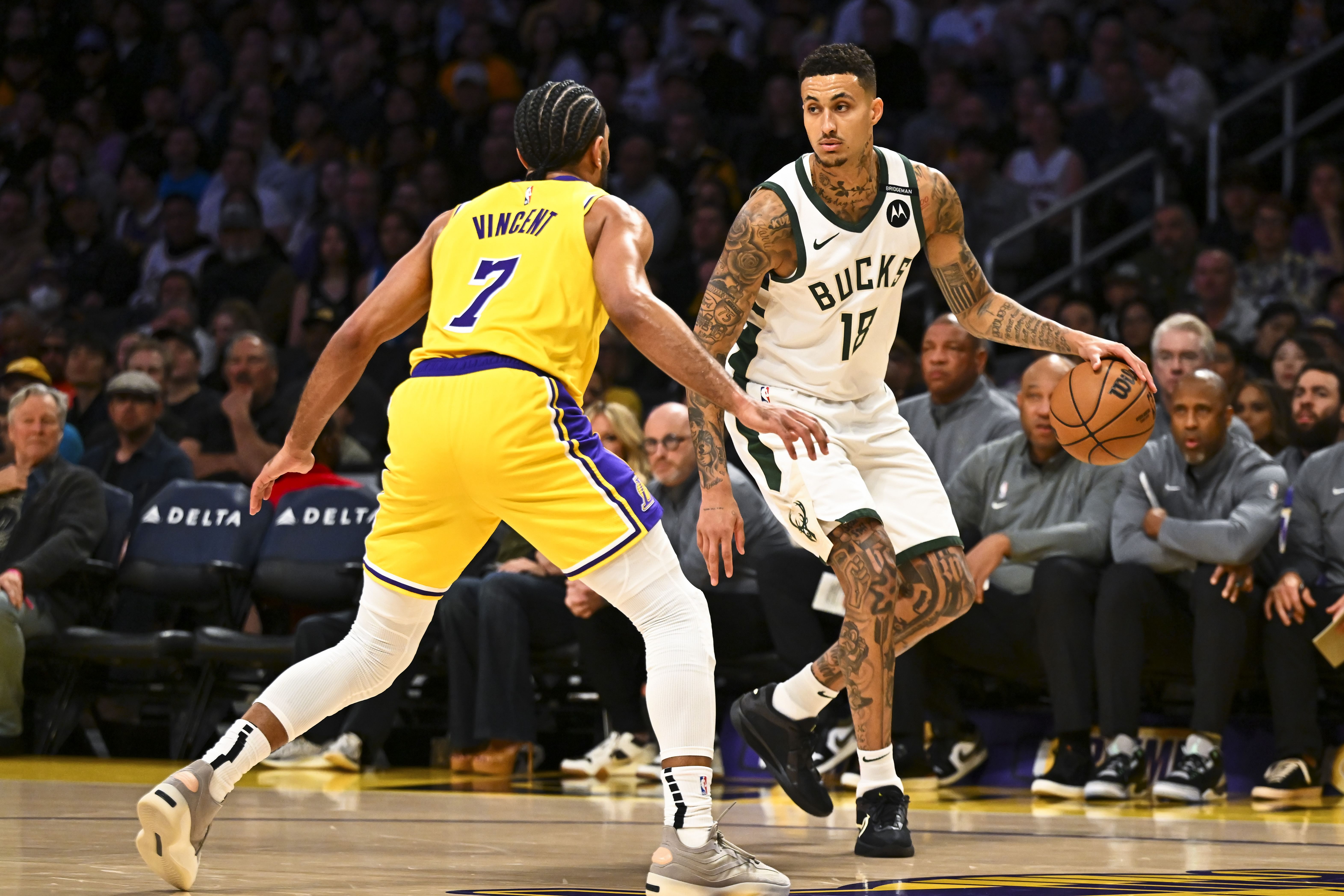 Mar 20, 2025; Los Angeles, California, USA; Milwaukee Bucks forward Kyle Kuzma (18) dribbles the ball against Los Angeles Lakers guard Gabe Vincent (7) during the first half at Crypto.com Arena. Mandatory Credit: Jonathan Hui-Imagn Images - Source: Imagn