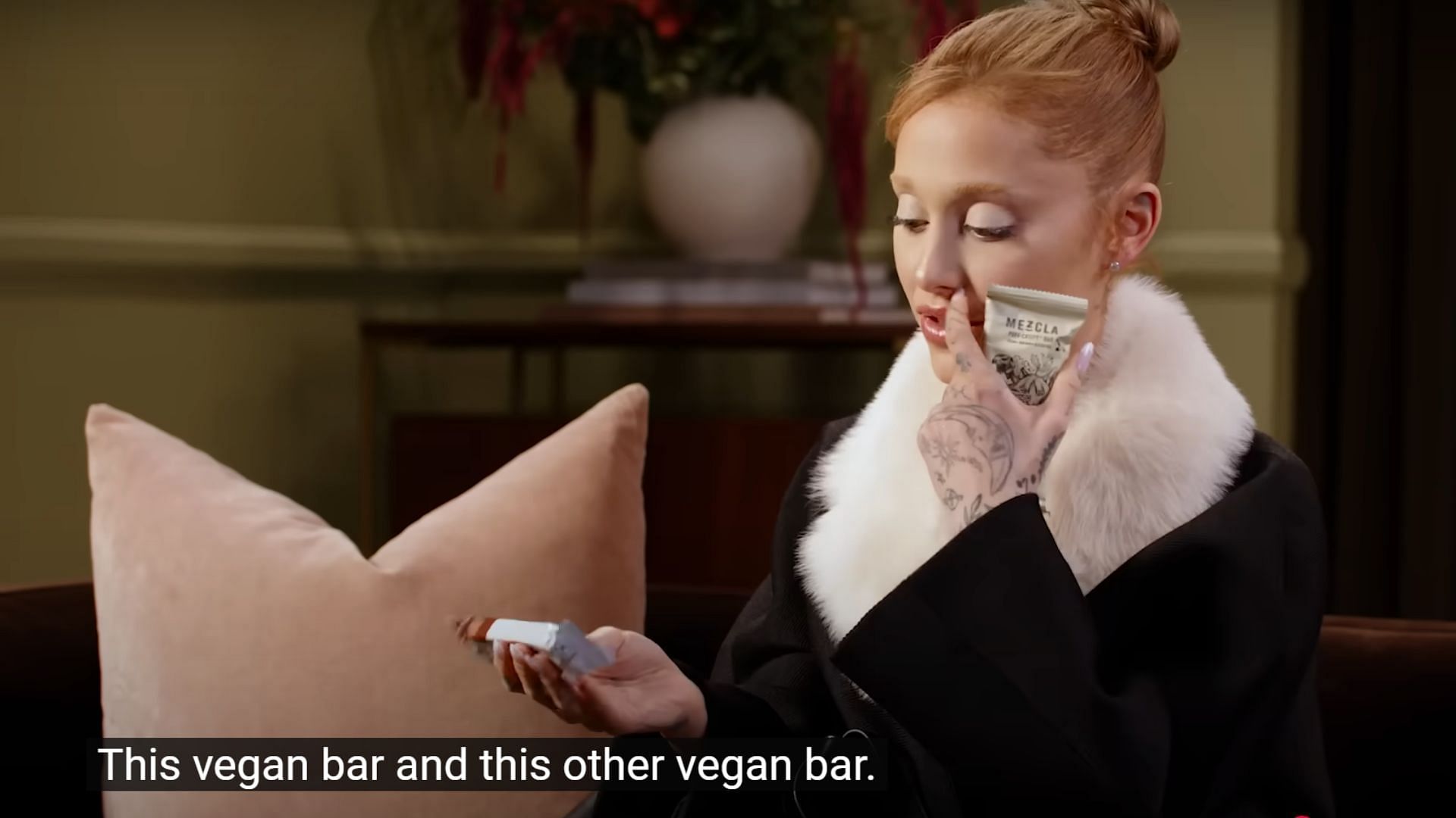 Ariana Grande showing her vegan protein bars (Image via YouTube/Vogue)