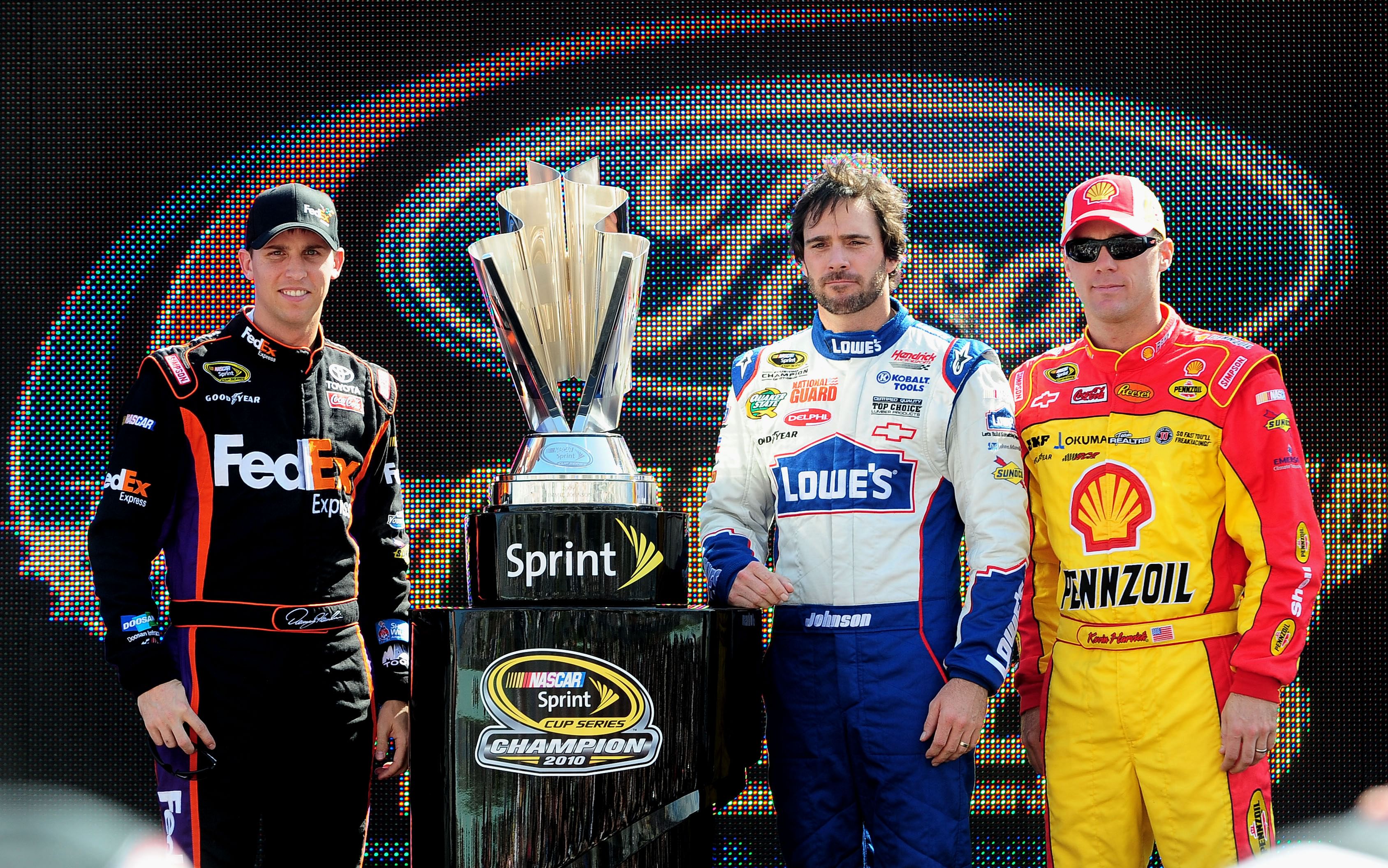 Denny Hamlin (left), Jimmie Johnson (center), and Kevin Harvick pose with the championship trophy before the Ford 400 at Homestead Miami Speedway.- Source: Imagn