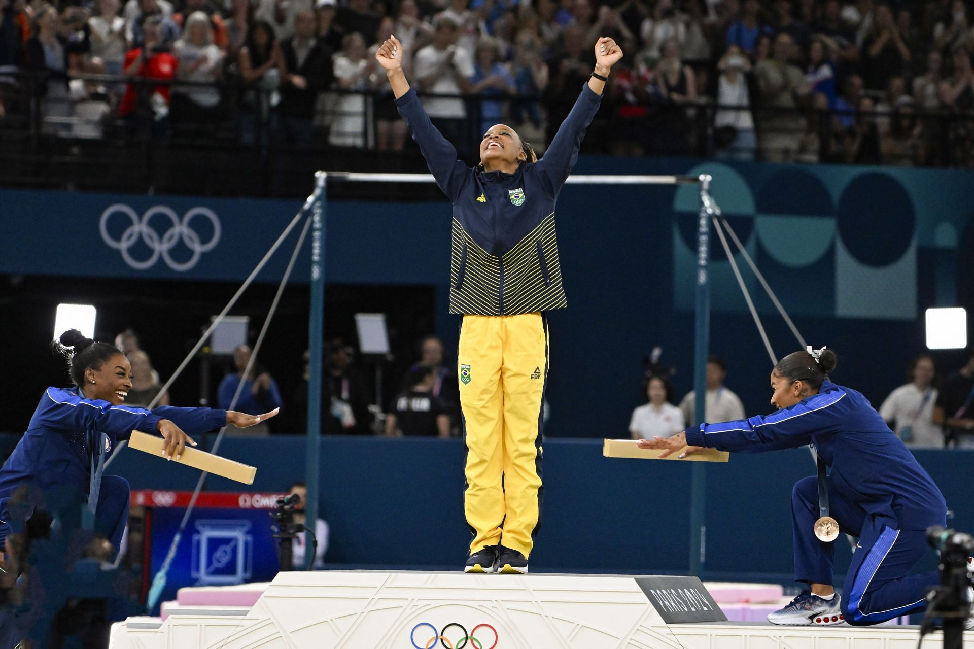 Simone Biles (L) and Jordan Chiles (R) of Team United States congratulate Rebeca Andrade (C) at Paris Olympics (Photo- Getty Images)