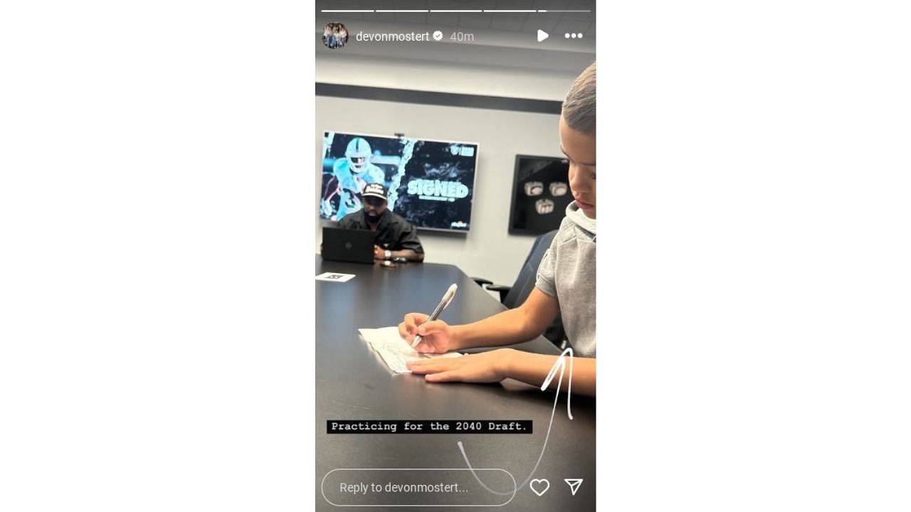 Devon Mostert&#039;s son Gunnar Grey draws something on paper at Las Vegas Raiders office