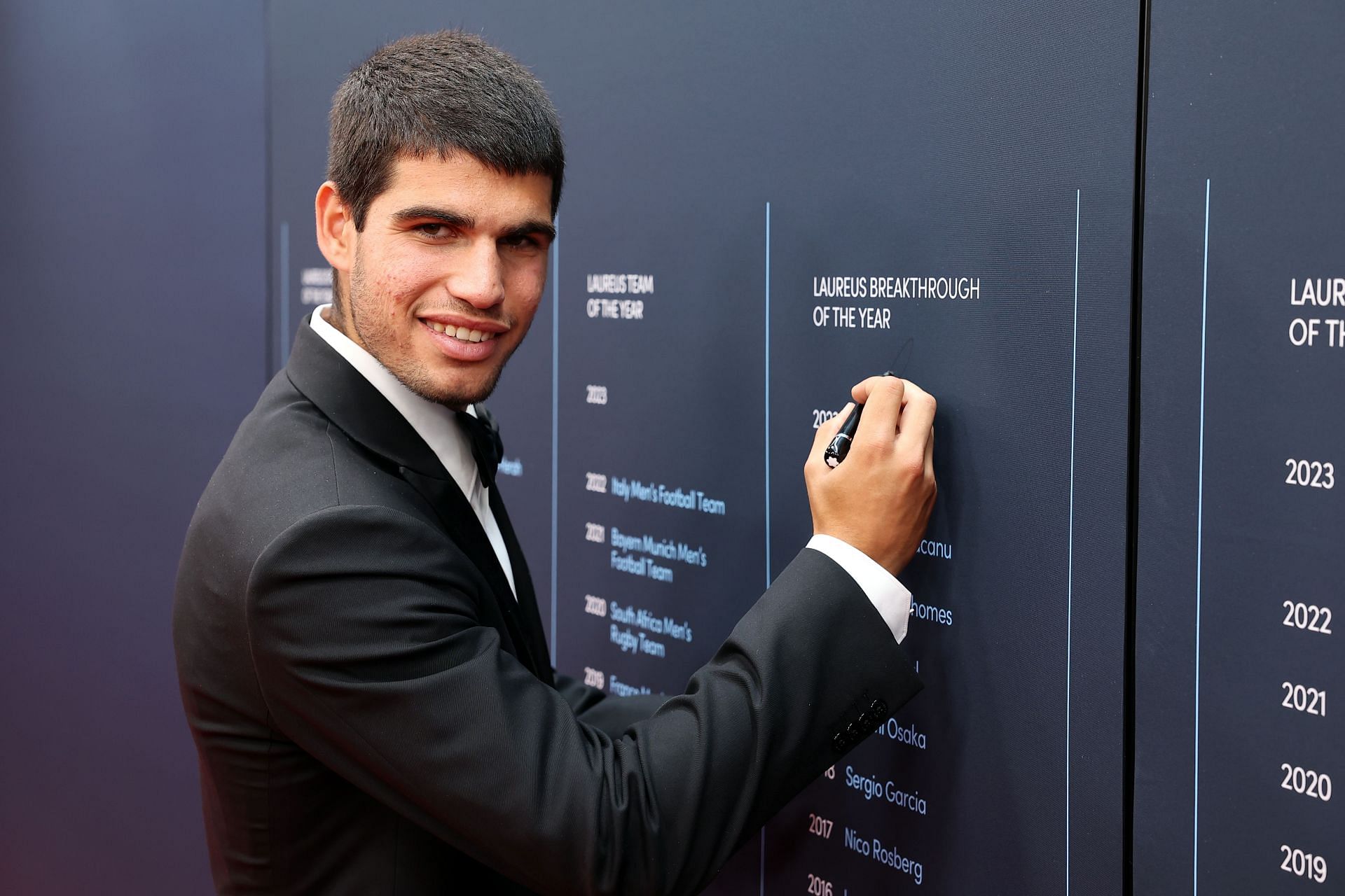 Carlos Alcaraz signs the Laureus World Sports Awards&#039; Winners Wall after winning the 2023 Laureus World Breakthrough of the Year Award (Source: Getty)