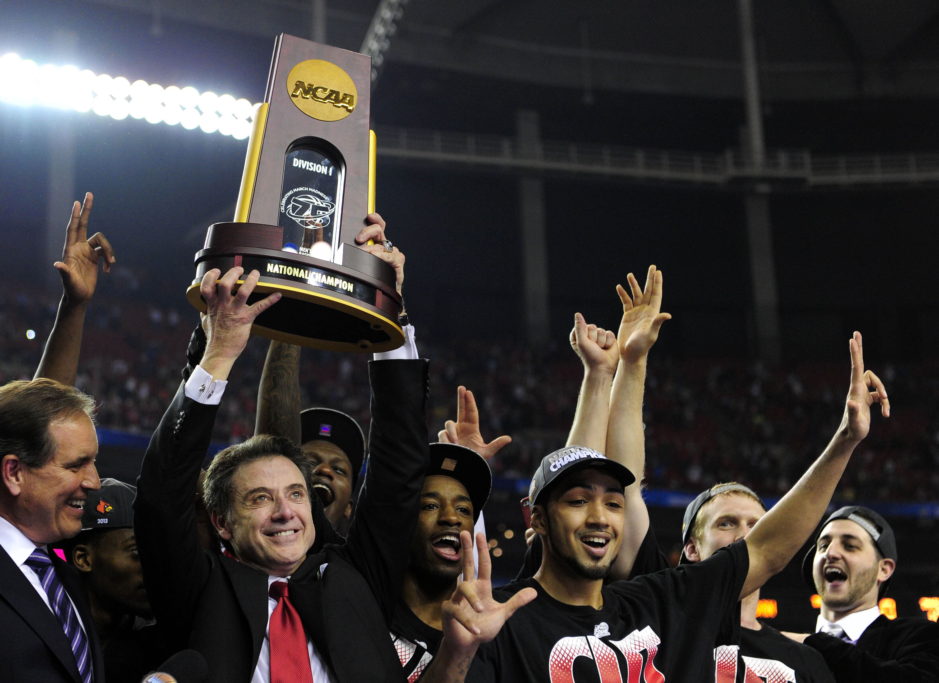 Louisville Cardinals head coach Rick Pitino holds the trophy with his team after they won the 2013 championship game against the Michigan Wolverines at the Georgia Dome. Photo: Imagn