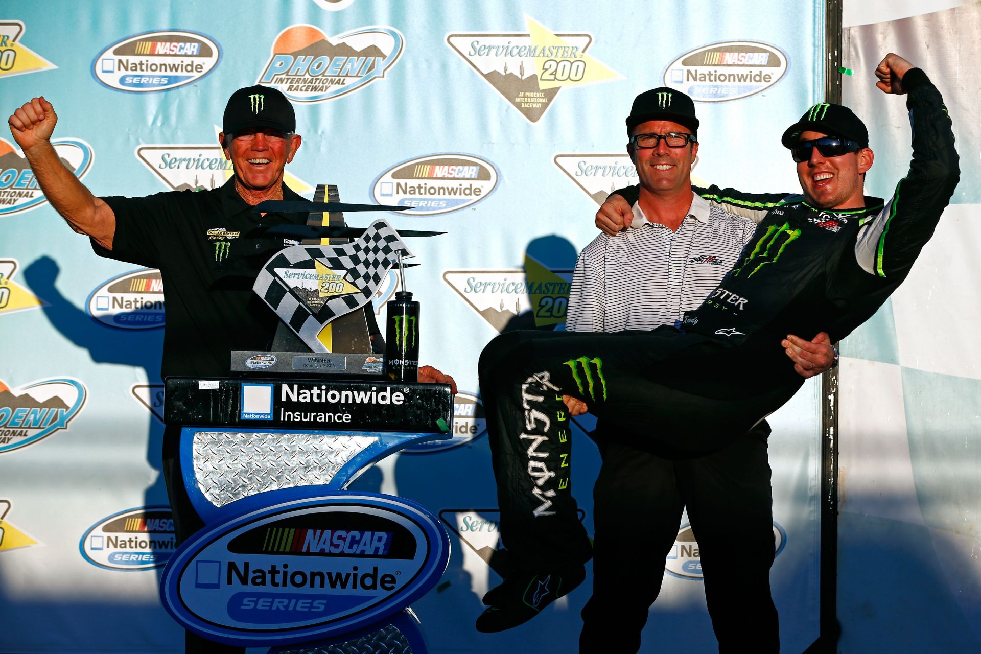 (L-R) Joe Gibbs, J.D. Gibbs, and Kyle Busch celebrate in victory lane on November 9, 2013- Source: Getty