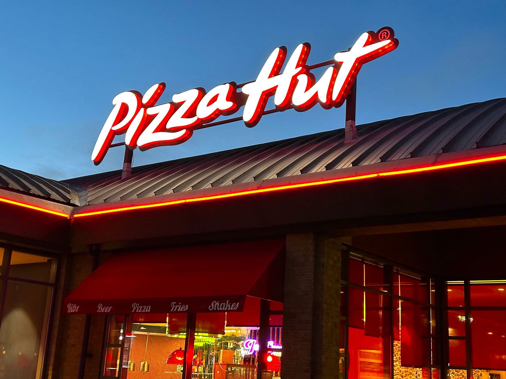 Pizza Hut store sign on building exterior, store frontage - Source: Getty