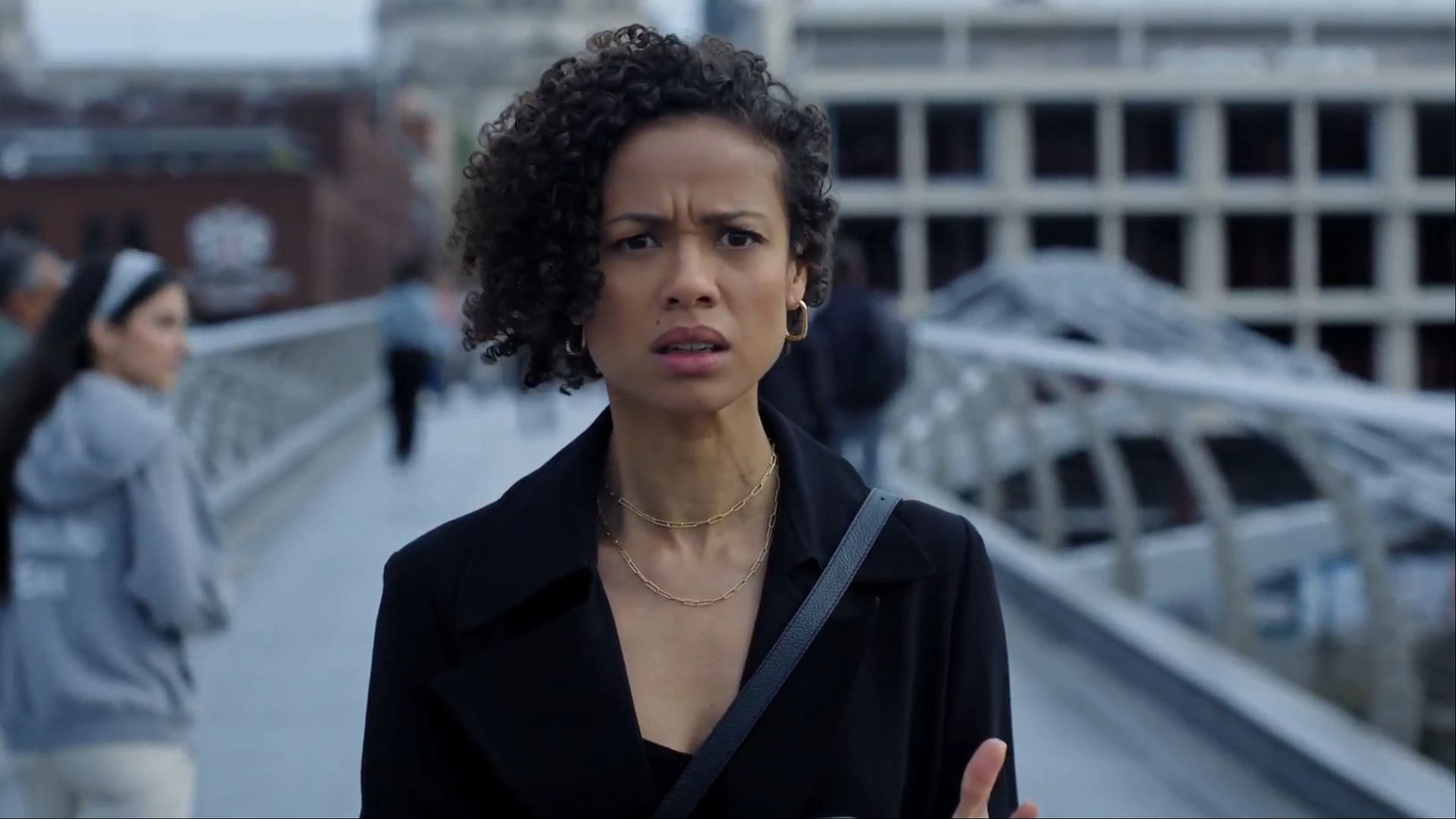 Sophie stands on a bridge in London, visibly shocked and concerned. (Image via AppleTV+)