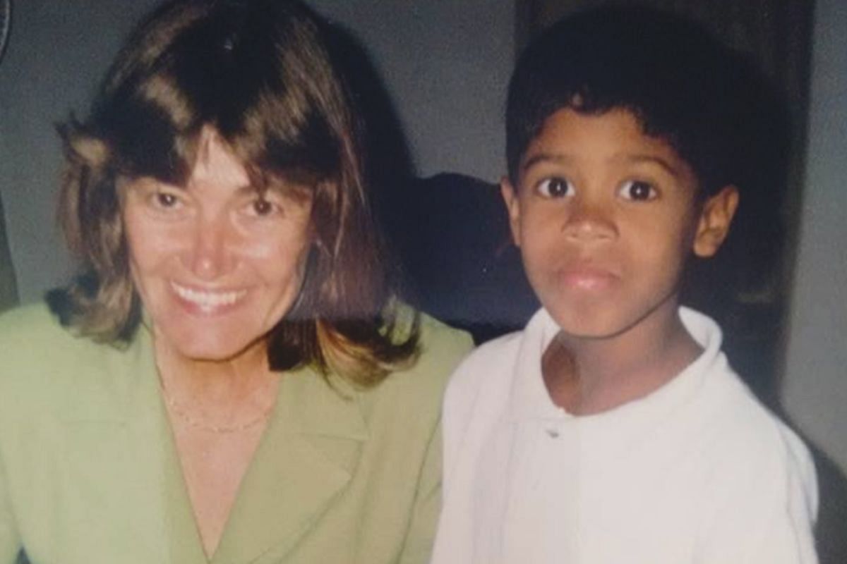 A young Adriano Moraes and his mother smile at the camera