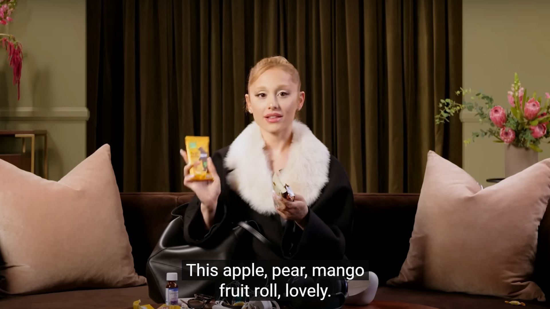 Ariana showing the fruit rolls she carries in her bag (Image via YouTube/Vogue)