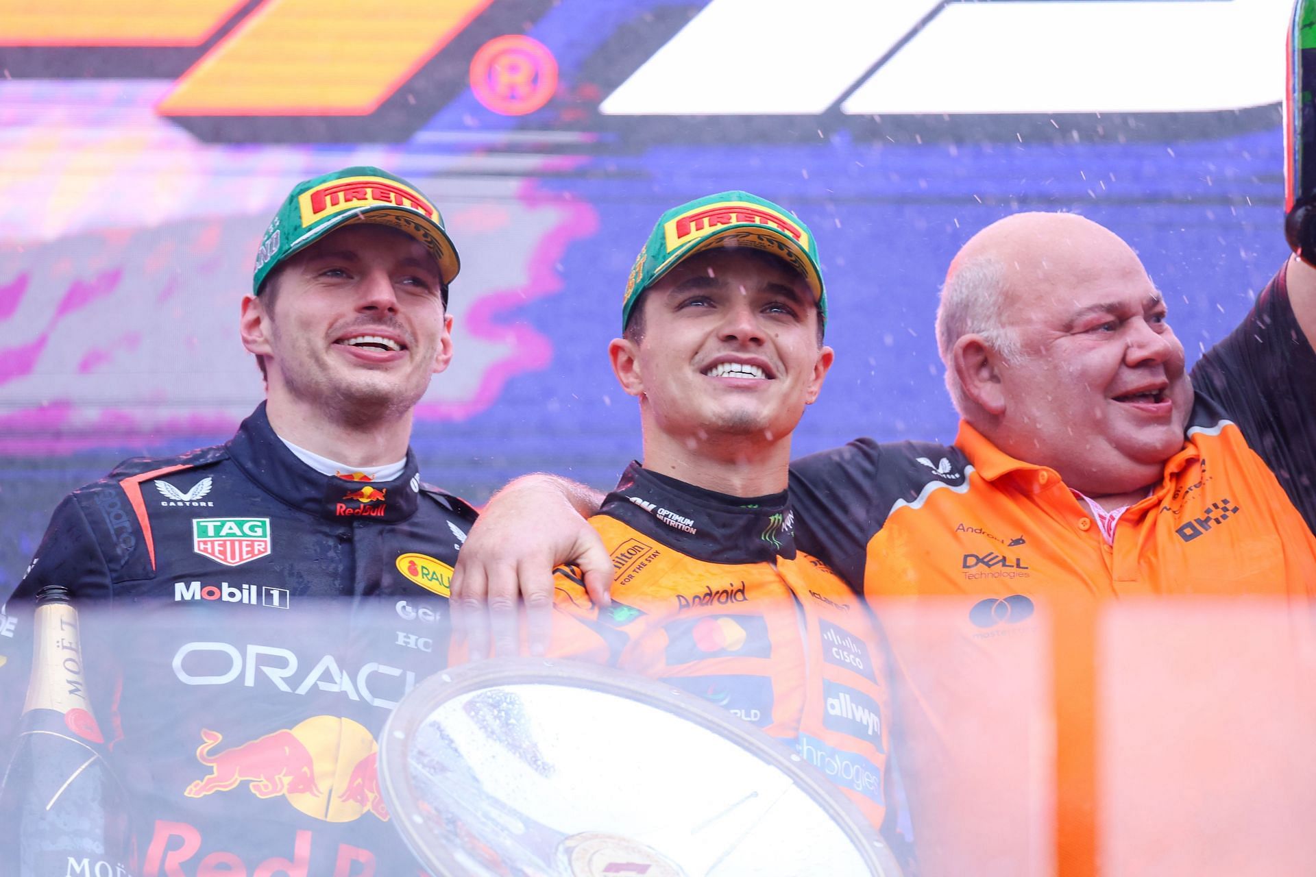 Max Verstappen [L] with Lando Norris [C] and McLaren staff [R] (Image: Getty)