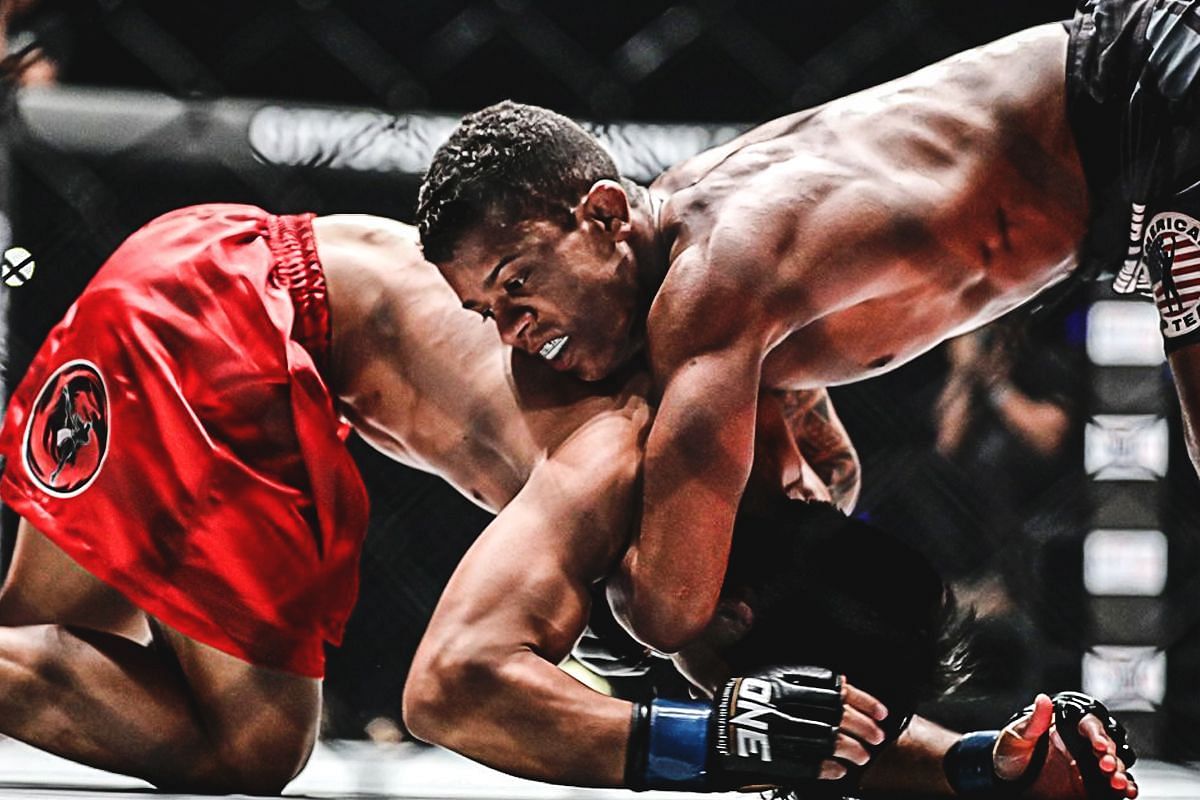 Adriano Moraes (R) locking his signature guilottine choke | Photo by ONE Championship