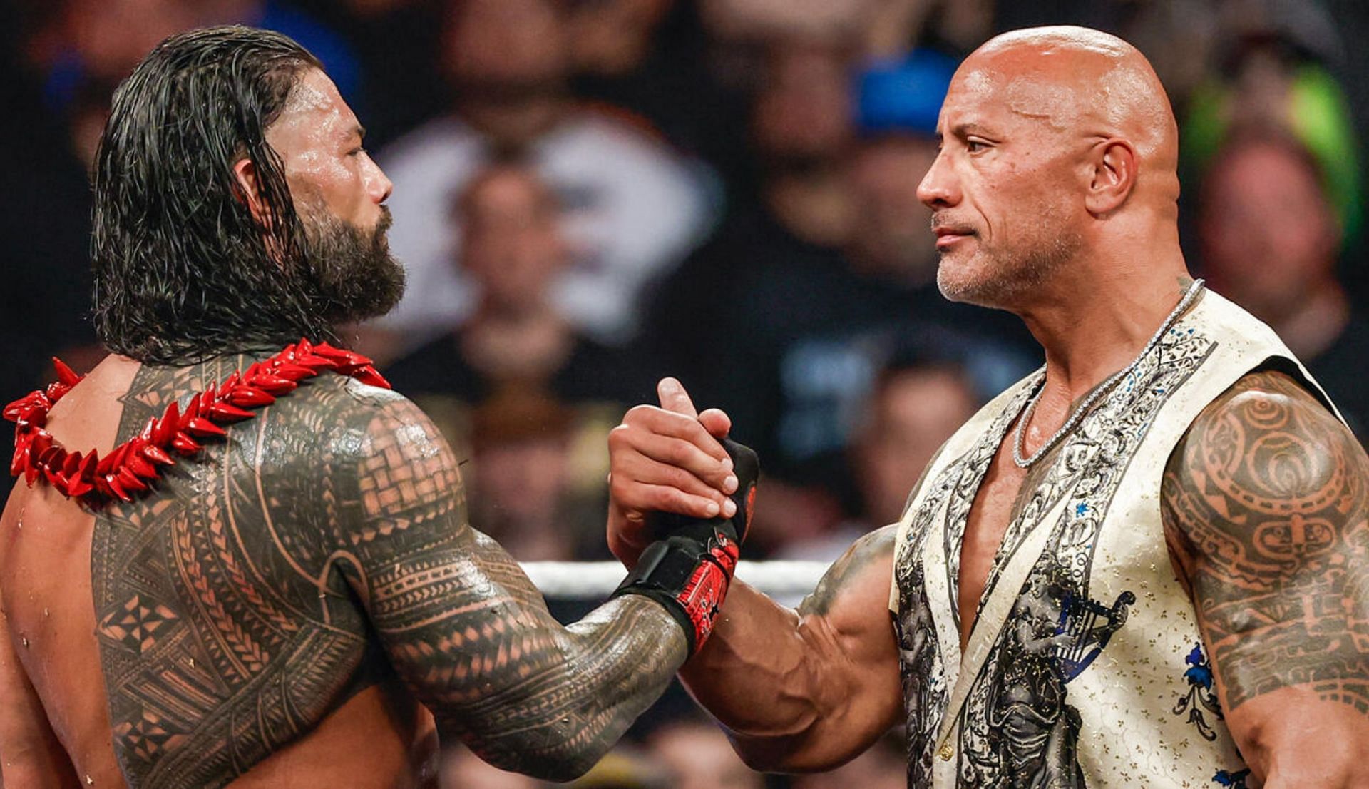 द रॉक और रोमन रेंस हाथ मिलाते हुए (Photo: WWE.com)
