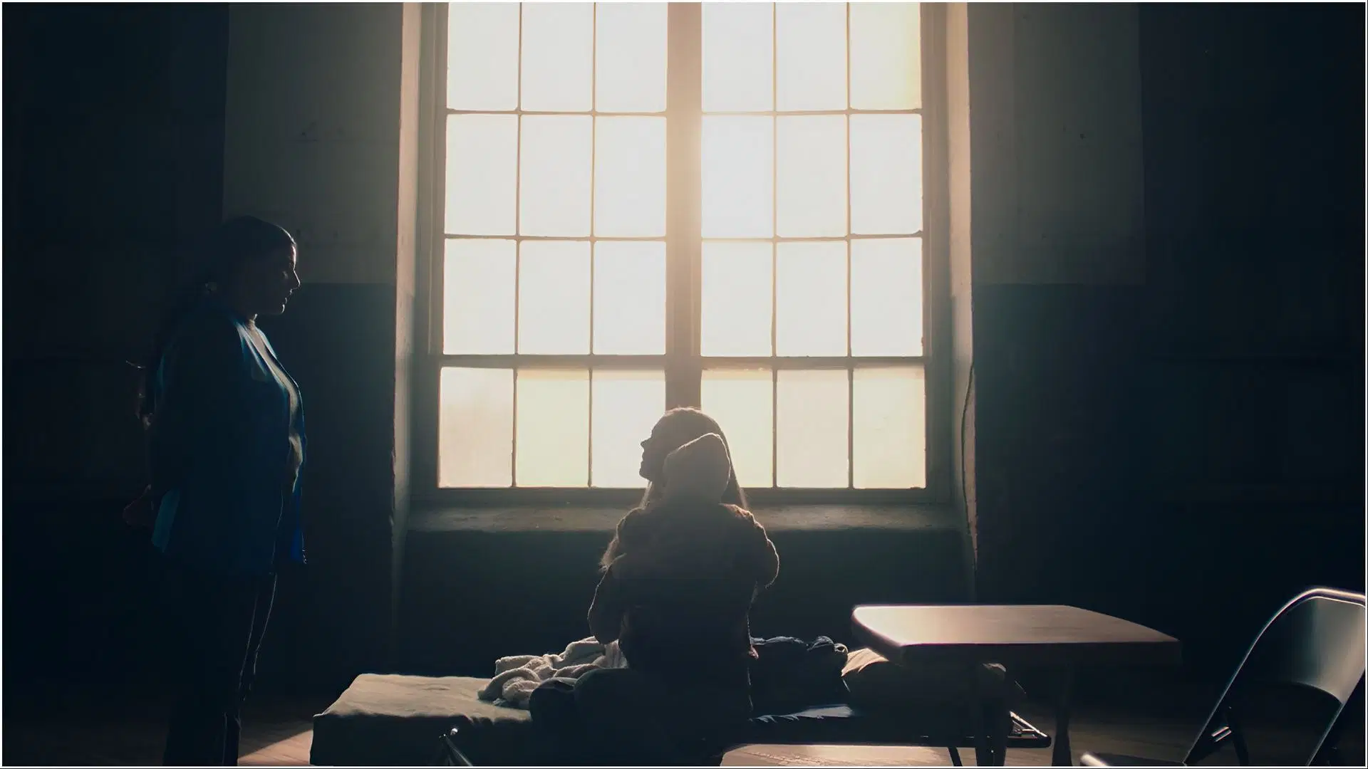 Serena sits in a refugee center with Noah after losing her status and citizenship in The Handmaid&rsquo;s Tale season 6. (Image via Hulu)