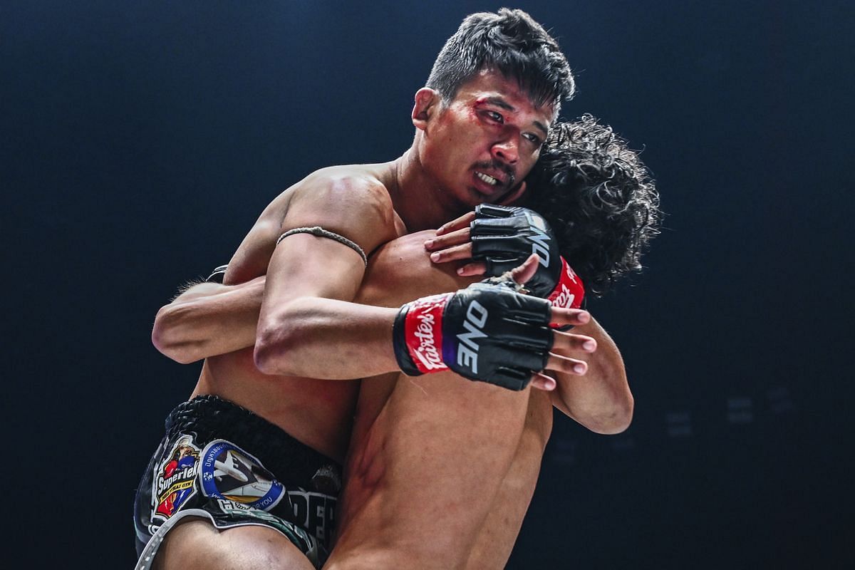 Superlek embraces Nabil Anane in the cage