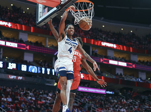 Feb 21, 2025; Houston, Texas, USA; Minnesota Timberwolves guard Rob Dillingham (4) dunks the ball as Houston Rockets forward Jae'Sean Tate (8) defends during the third quarter at Toyota Center. Mandatory Credit: Troy Taormina-Imagn Images - Source: Imagn