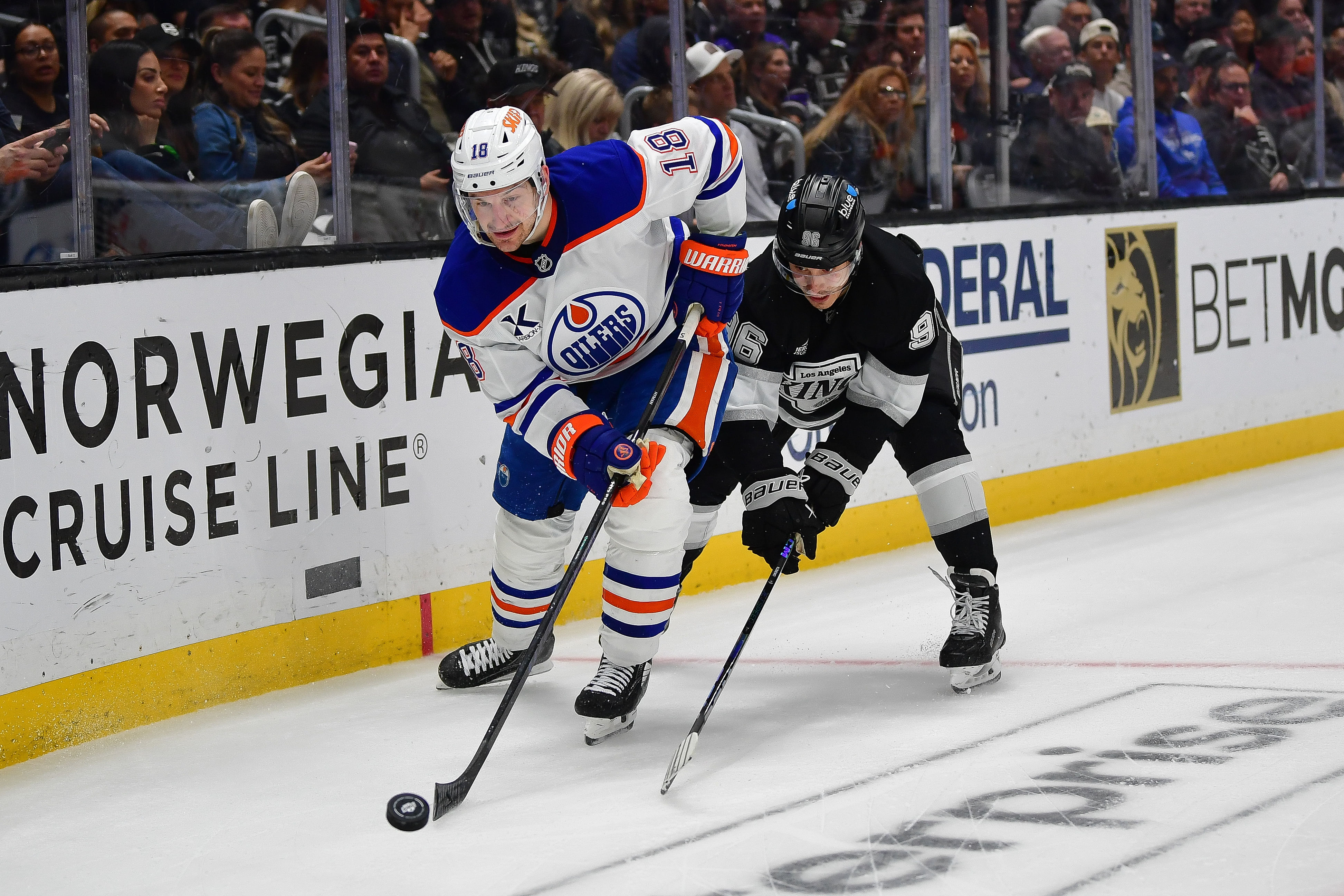 Apr 29, 2025; Los Angeles, California, USA; Edmonton Oilers left wing Zach Hyman (18) moves the puck ahead of Los Angeles Kings left wing Andrei Kuzmenko (96) during the third period in game five of the first round of the 2025 Stanley Cup Playoffs at Crypto.com Arena. Mandatory Credit: Gary A. Vasquez-Imagn Images - Source: Imagn