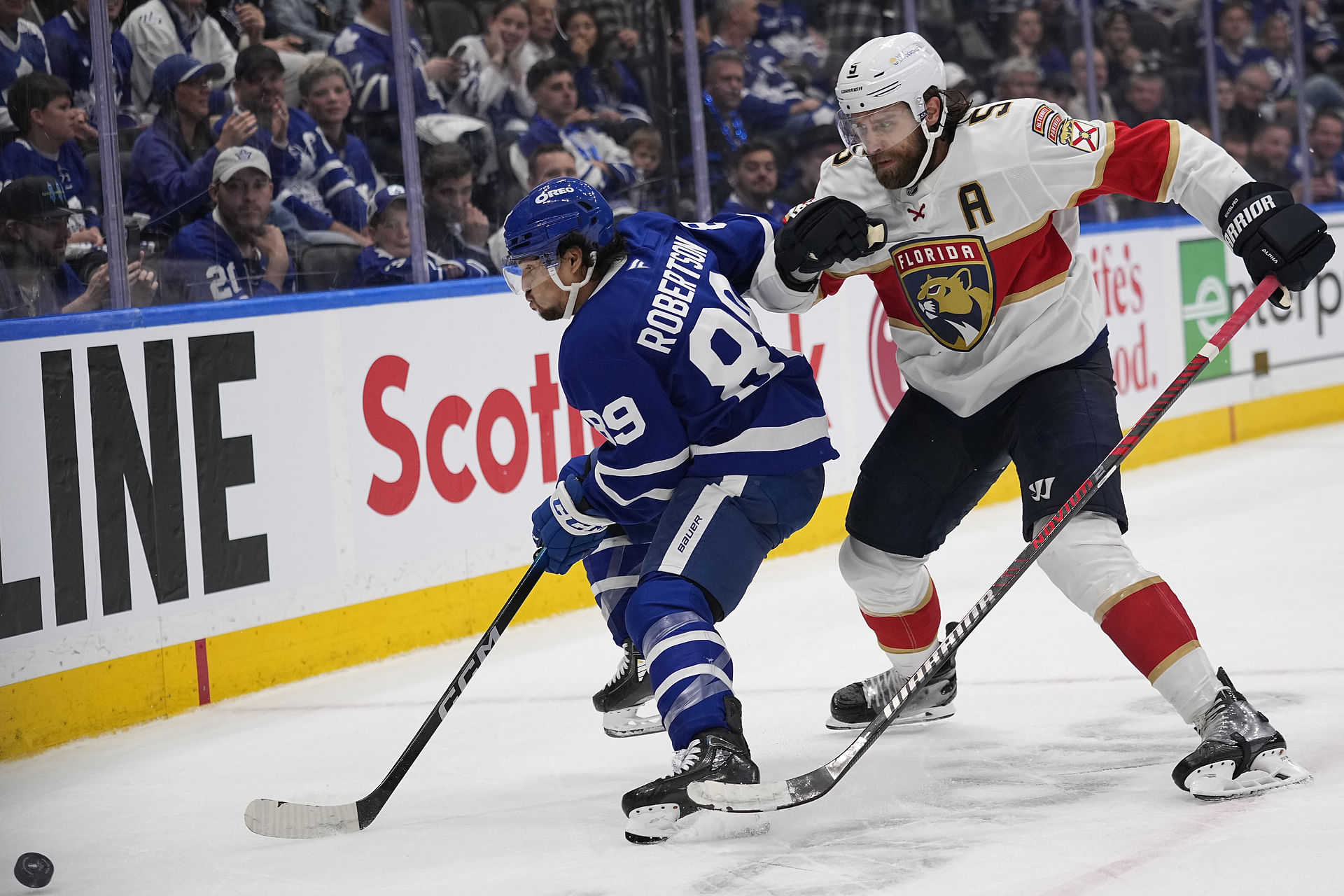 May 14, 2025; Toronto, Ontario, CAN; Florida Panthers defenseman Aaron Ekblad (5) goes to check Toronto Maple Leafs forward Nicholas Robertson (89) as he goes for the puck during the third period of game five of the second round of the 2025 Stanley Cup Playoffs at Scotiabank Arena. Mandatory Credit: John E. Sokolowski-Imagn Images - Source: Imagn