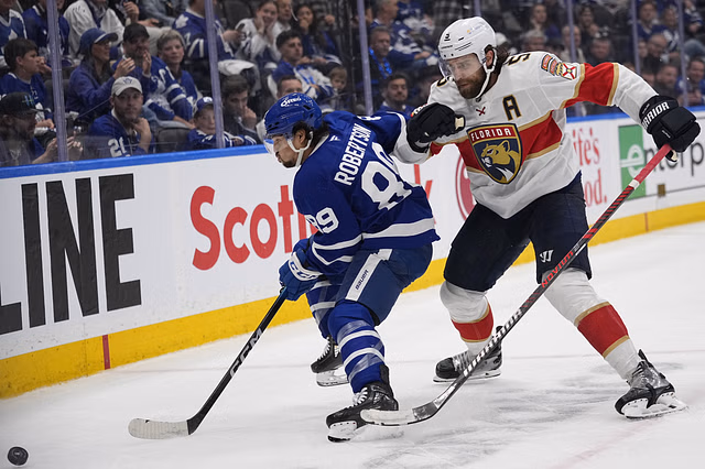 May 14, 2025; Toronto, Ontario, CAN; Florida Panthers defenseman Aaron Ekblad (5) goes to check Toronto Maple Leafs forward Nicholas Robertson (89) as he goes for the puck during the third period of game five of the second round of the 2025 Stanley Cup Playoffs at Scotiabank Arena. Mandatory Credit: John E. Sokolowski-Imagn Images - Source: Imagn