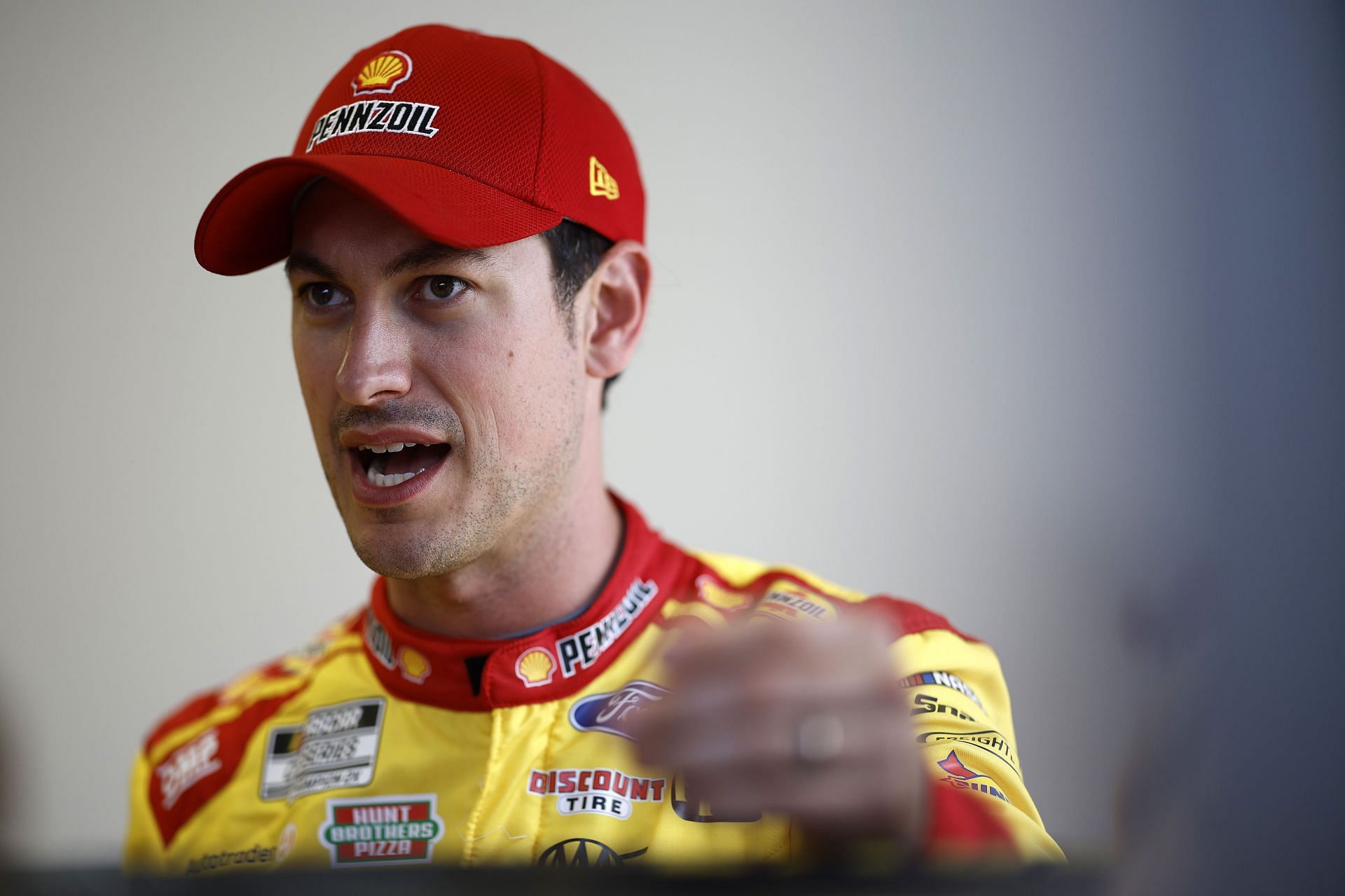 Joey Logano speaks with his crew in the garage area during practice for the Daytona 500 - Source: Getty